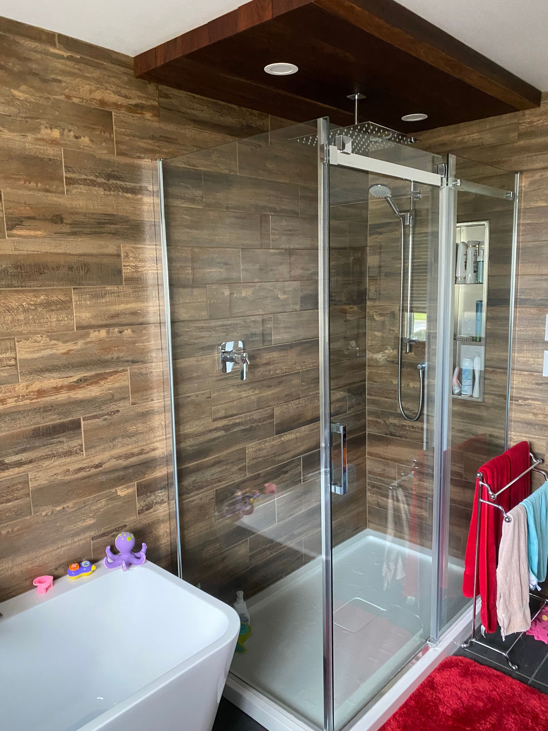 Une salle de bain avec baignoire, douche et murs en bois.