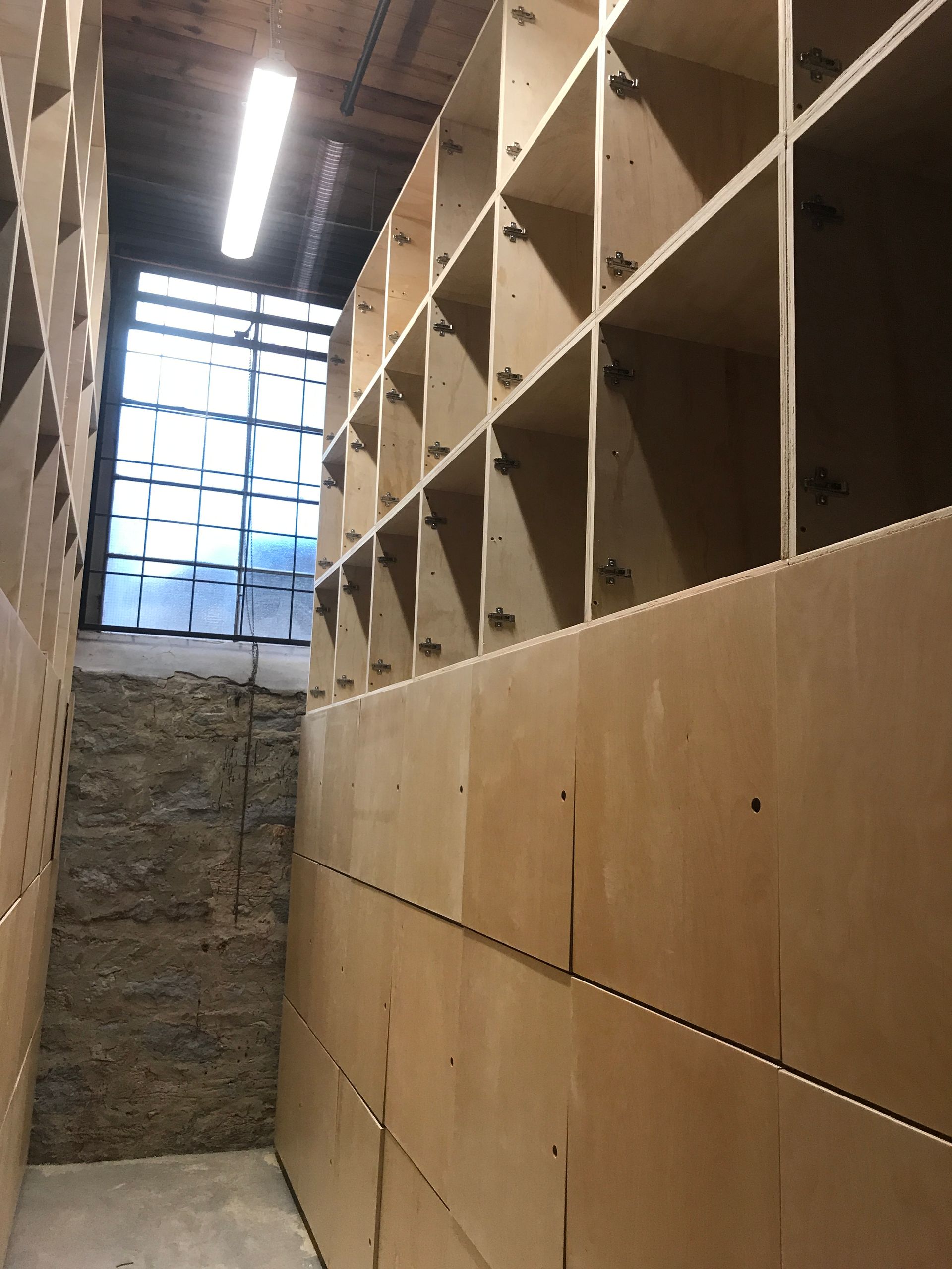 Une pièce avec beaucoup d'étagères et une fenêtre