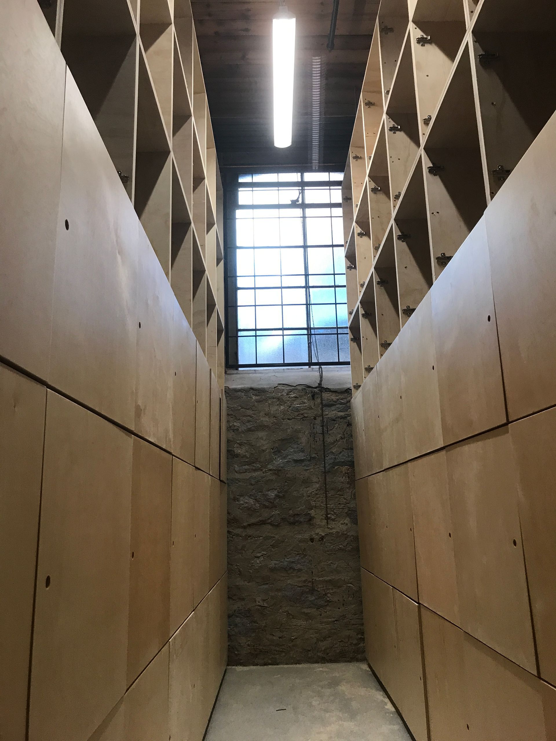 Un long couloir avec des étagères et une lumière suspendue au plafond