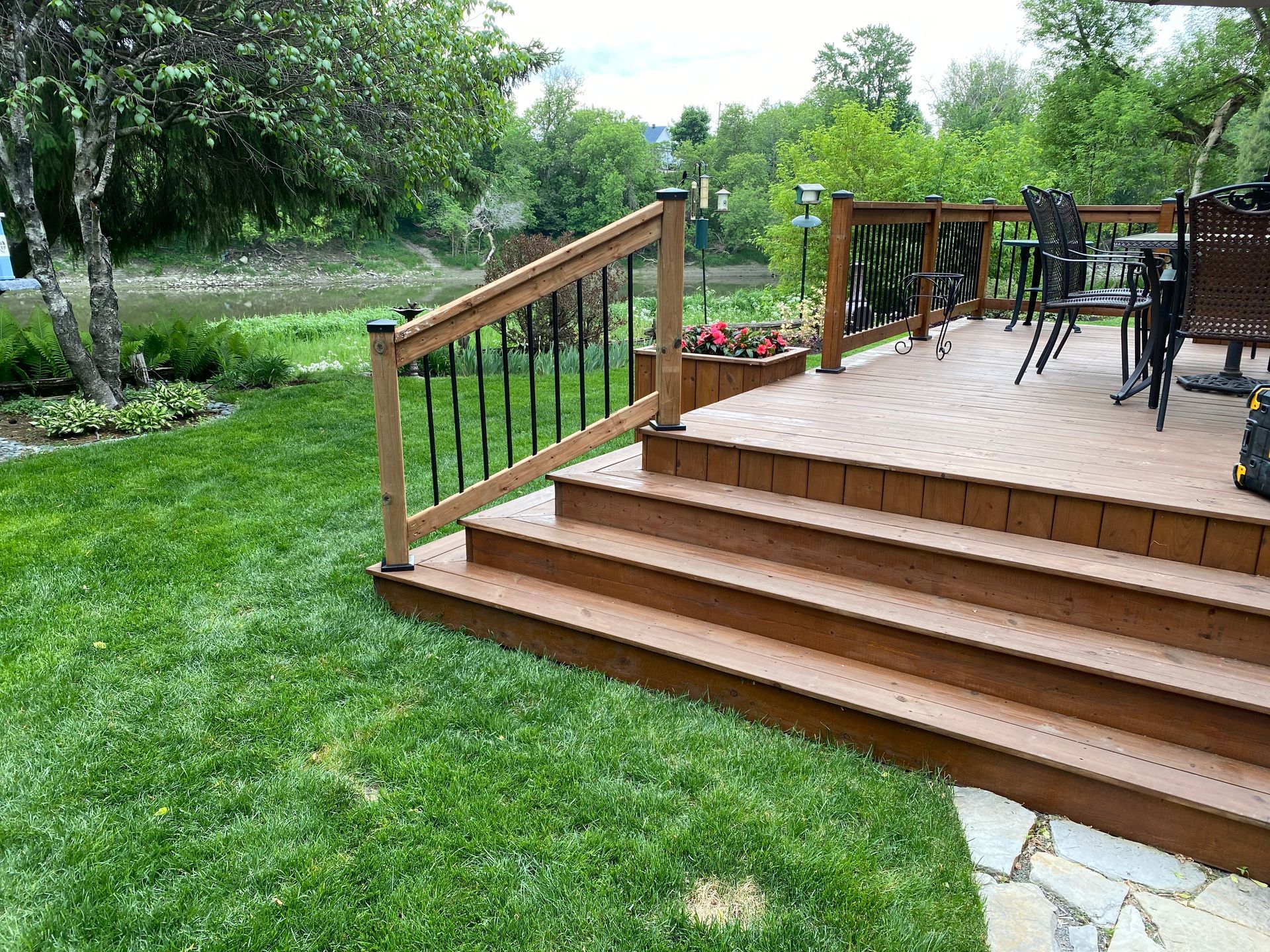 Une terrasse en bois avec des escaliers et une balustrade dans une cour arrière.