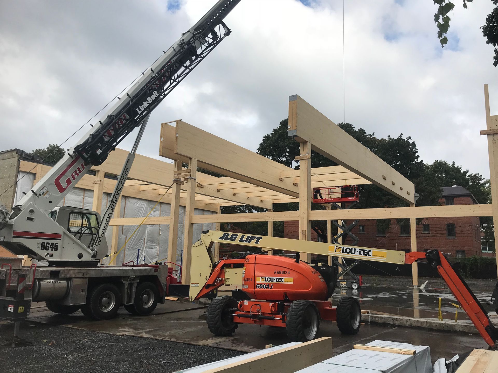 Un chantier avec une grue et un élévateur JLG