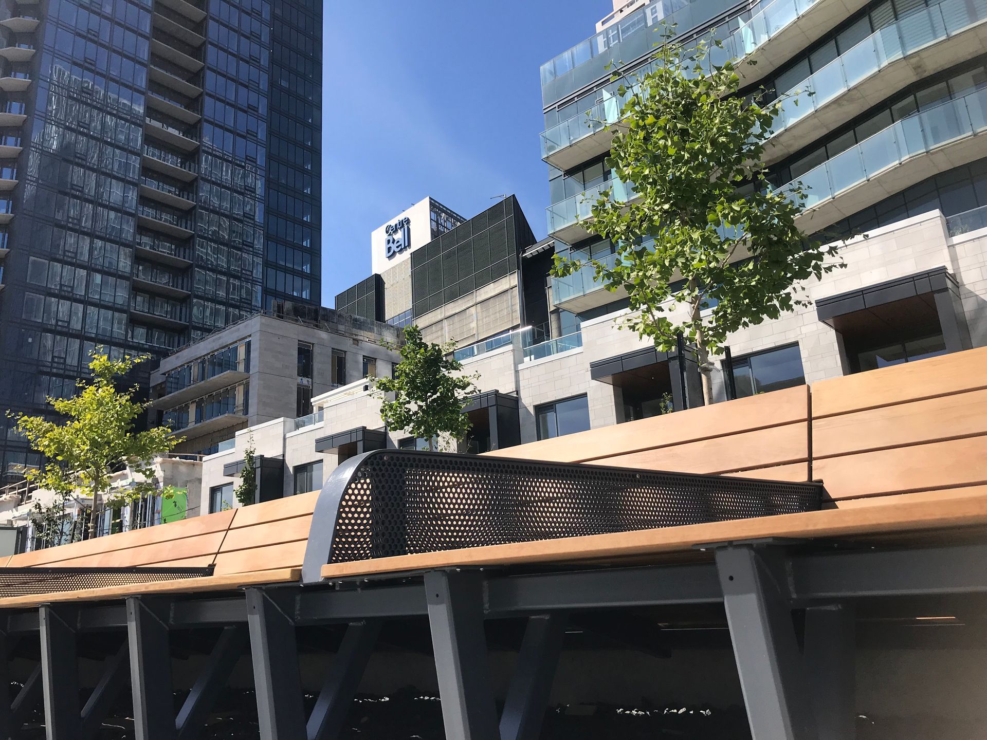 Un banc en bois est assis devant un grand bâtiment.