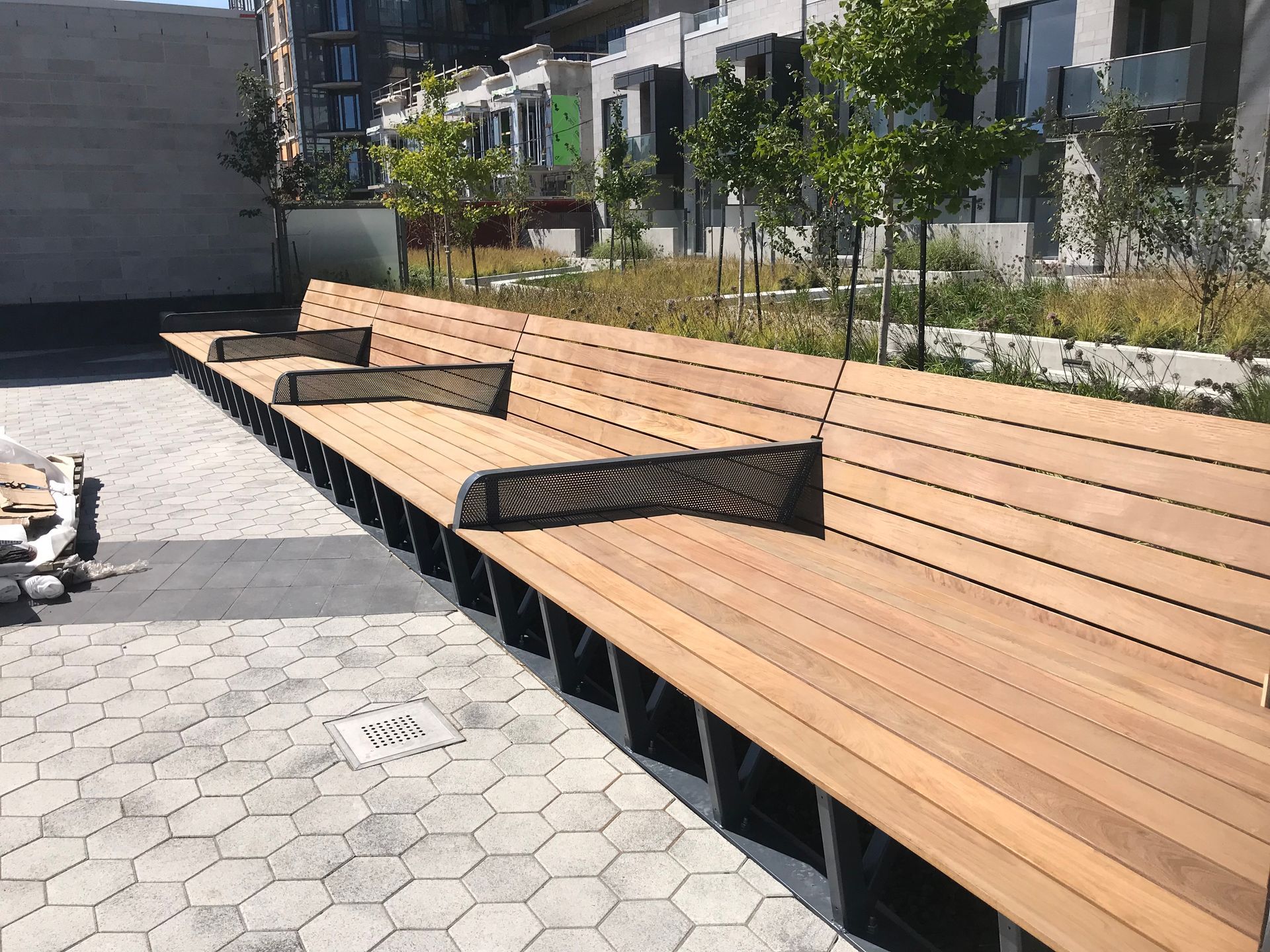 Une rangée de bancs en bois est alignée dans un parc.