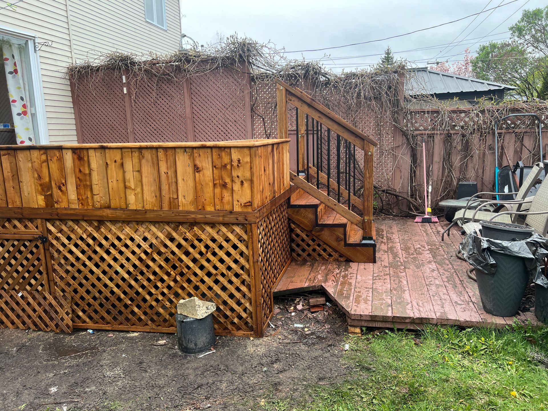 Une terrasse en bois avec des escaliers et une clôture dans l'arrière-cour d'une maison.