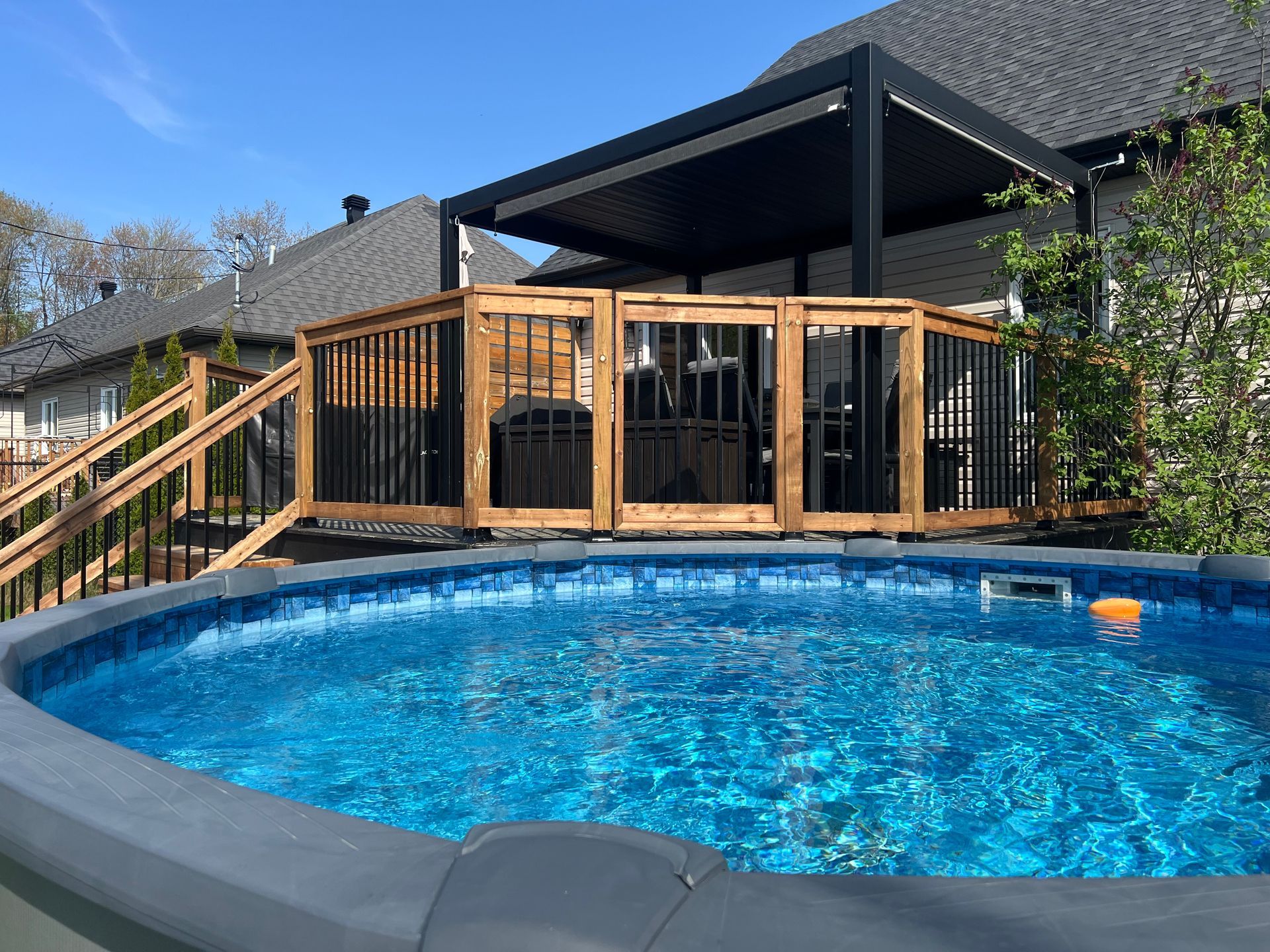 Une grande piscine avec une terrasse en bois en arrière-plan.