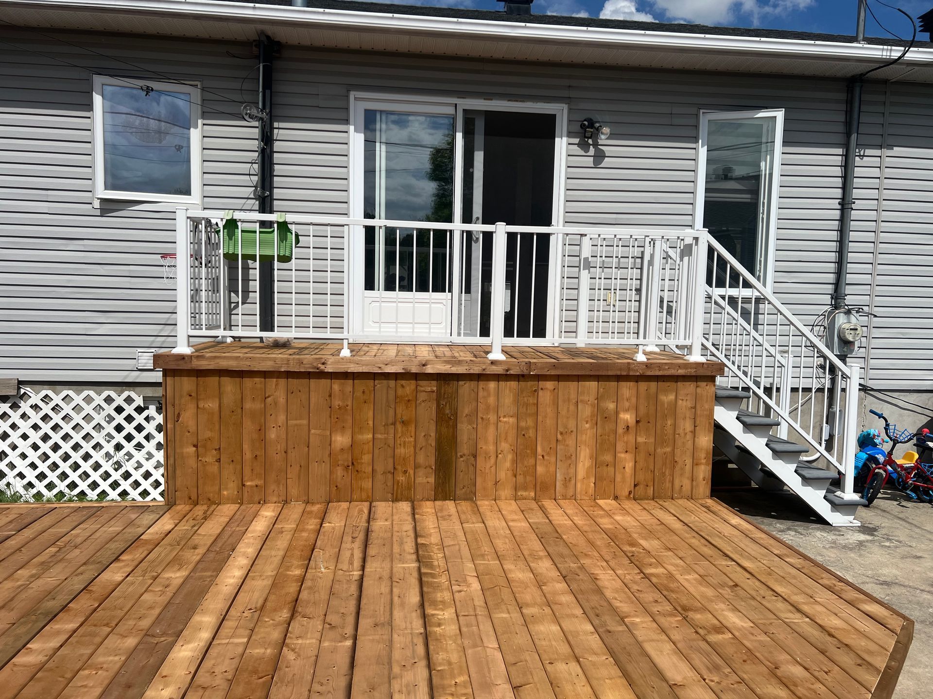Une terrasse en bois avec des escaliers menant à l'arrière d'une maison.
