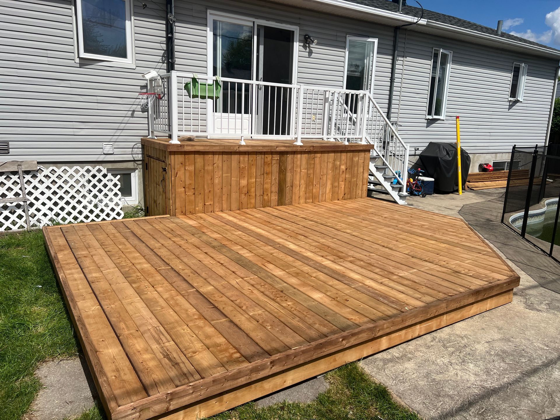 Une terrasse en bois se trouve devant une maison.