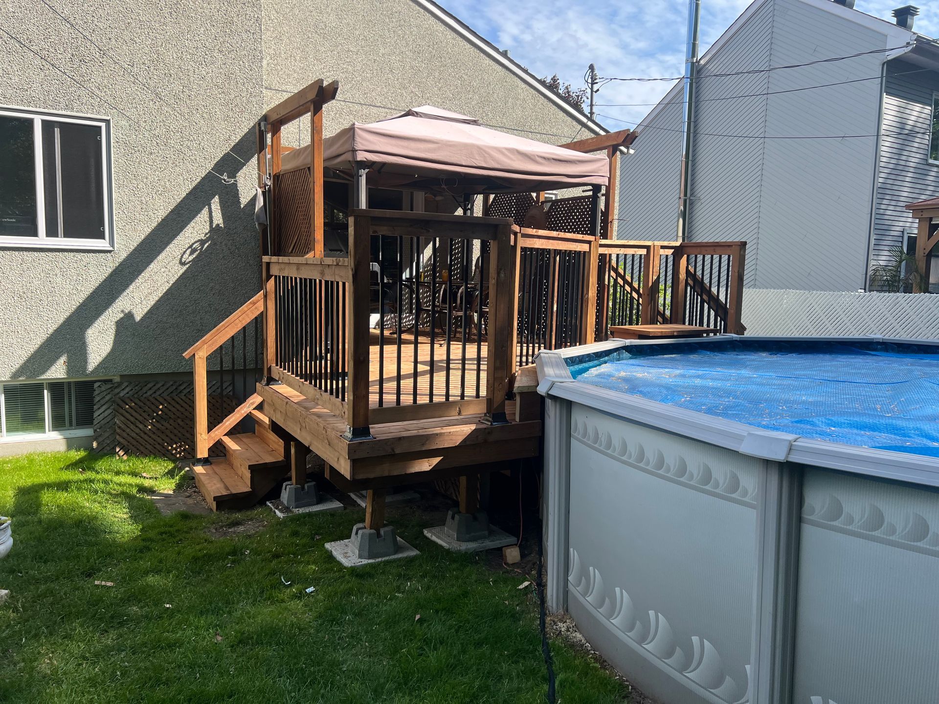 Une cour arrière avec une terrasse en bois et une piscine.