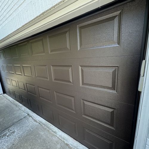 A close up of a brown garage door on a house.