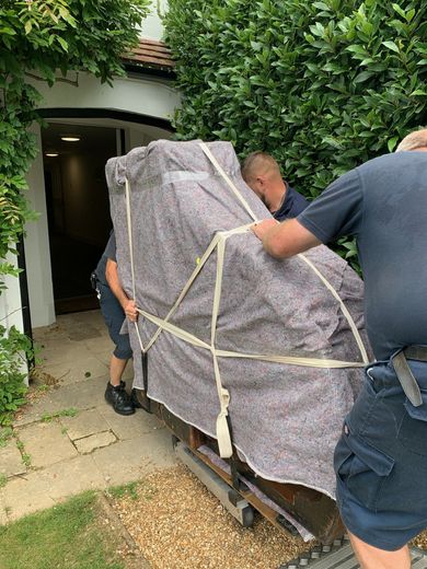 An image of Laceys Removals Isle of Wight moving a piano