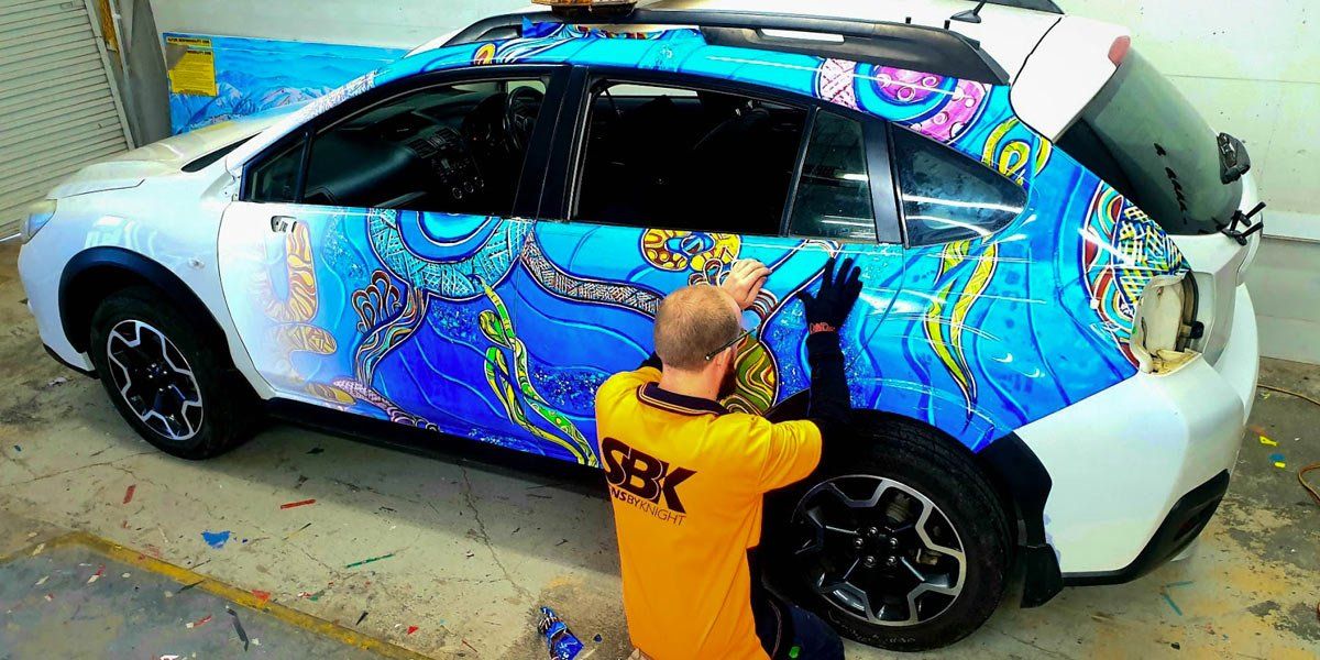 man working on car signage