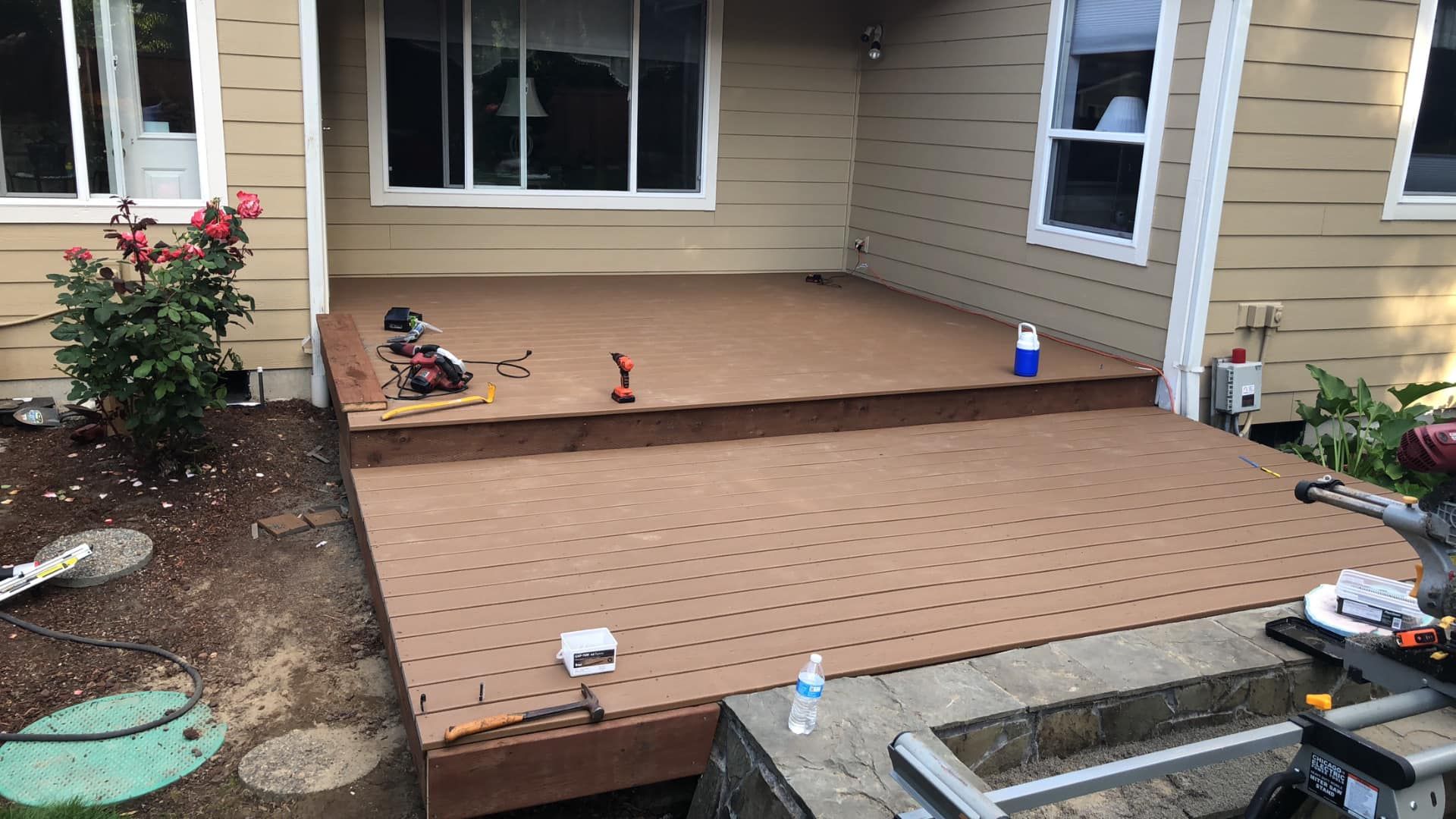 A wooden deck is being built in front of a house.