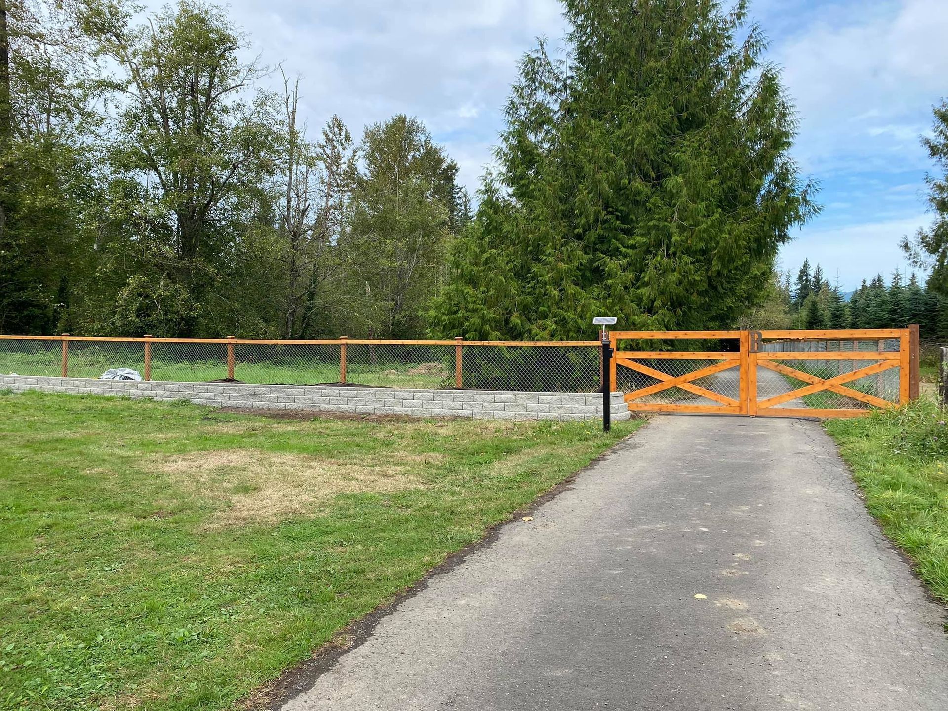 There is a wooden fence along the side of the road.