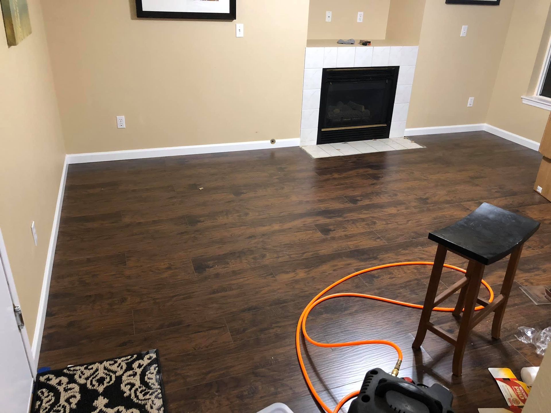 A living room with hardwood floors and a fireplace.