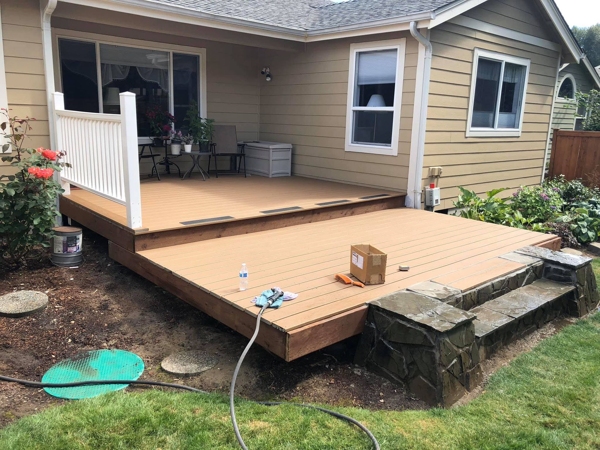 A wooden deck is sitting in front of a house.