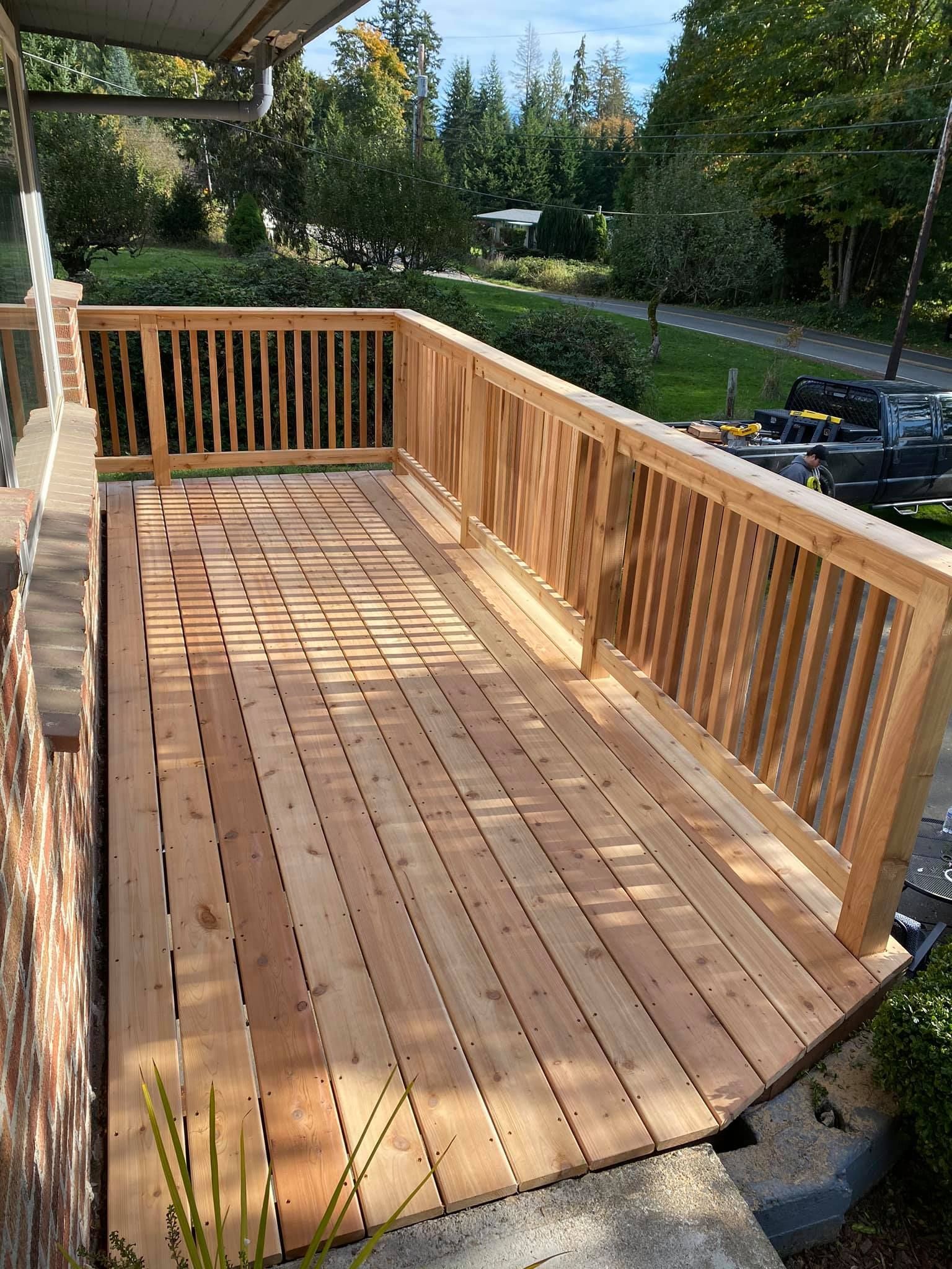 A wooden deck with a railing is sitting on top of a brick wall.