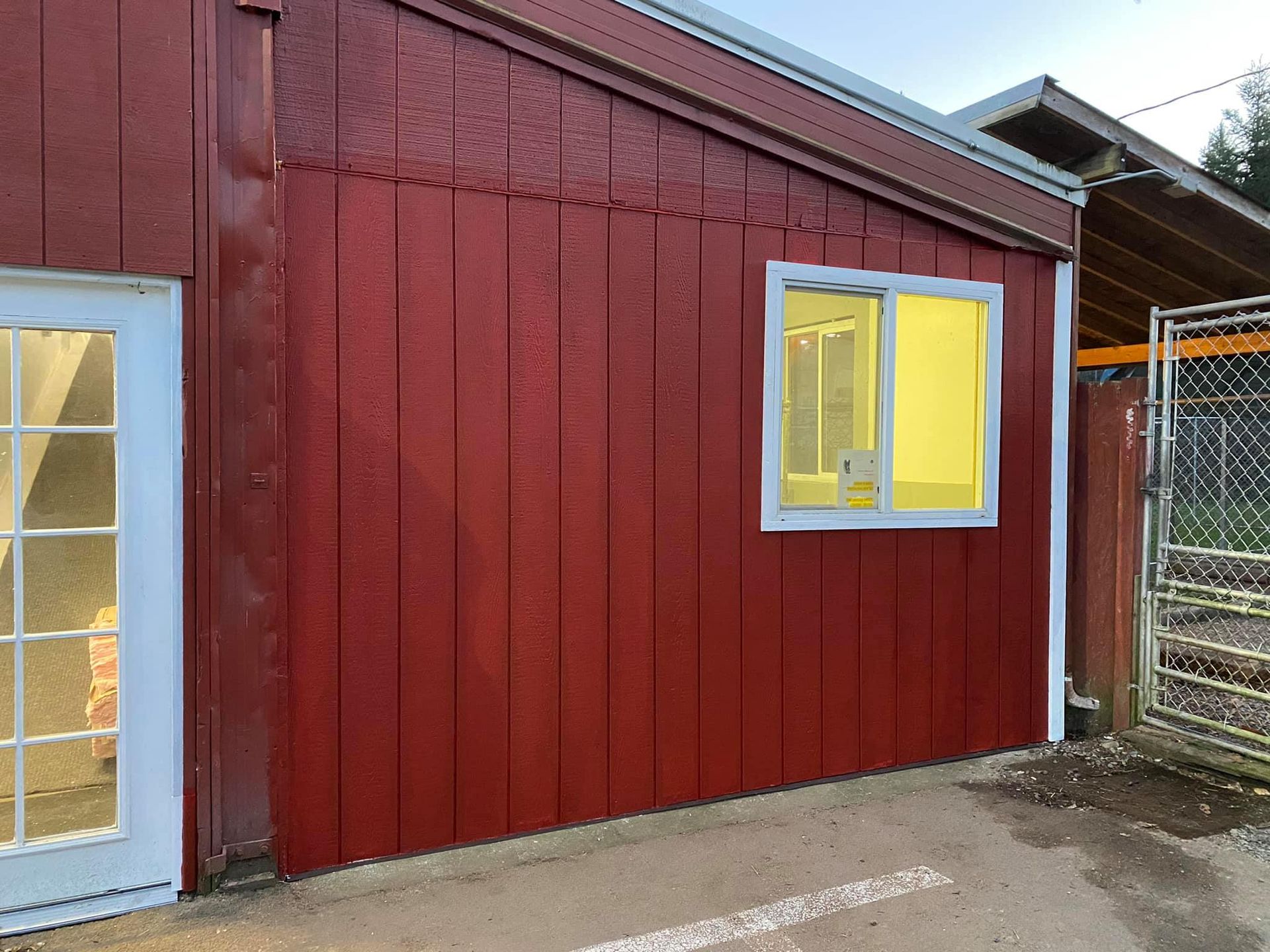A red building with a white door and a window.