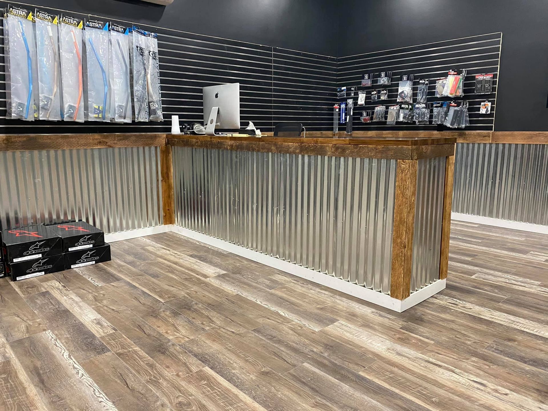 A long metal counter in a store with a wooden floor.