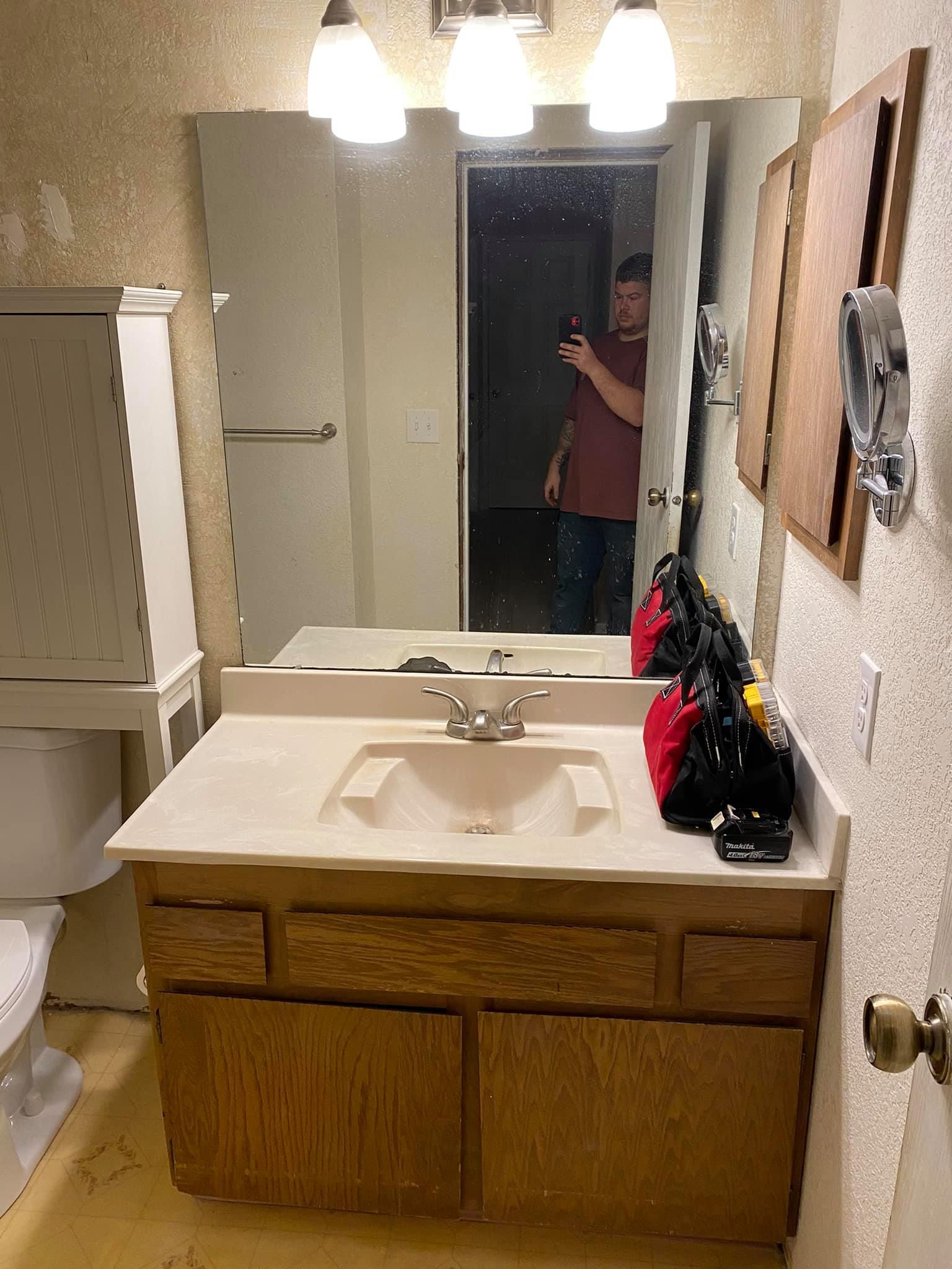 A man is taking a picture of himself in a bathroom mirror.