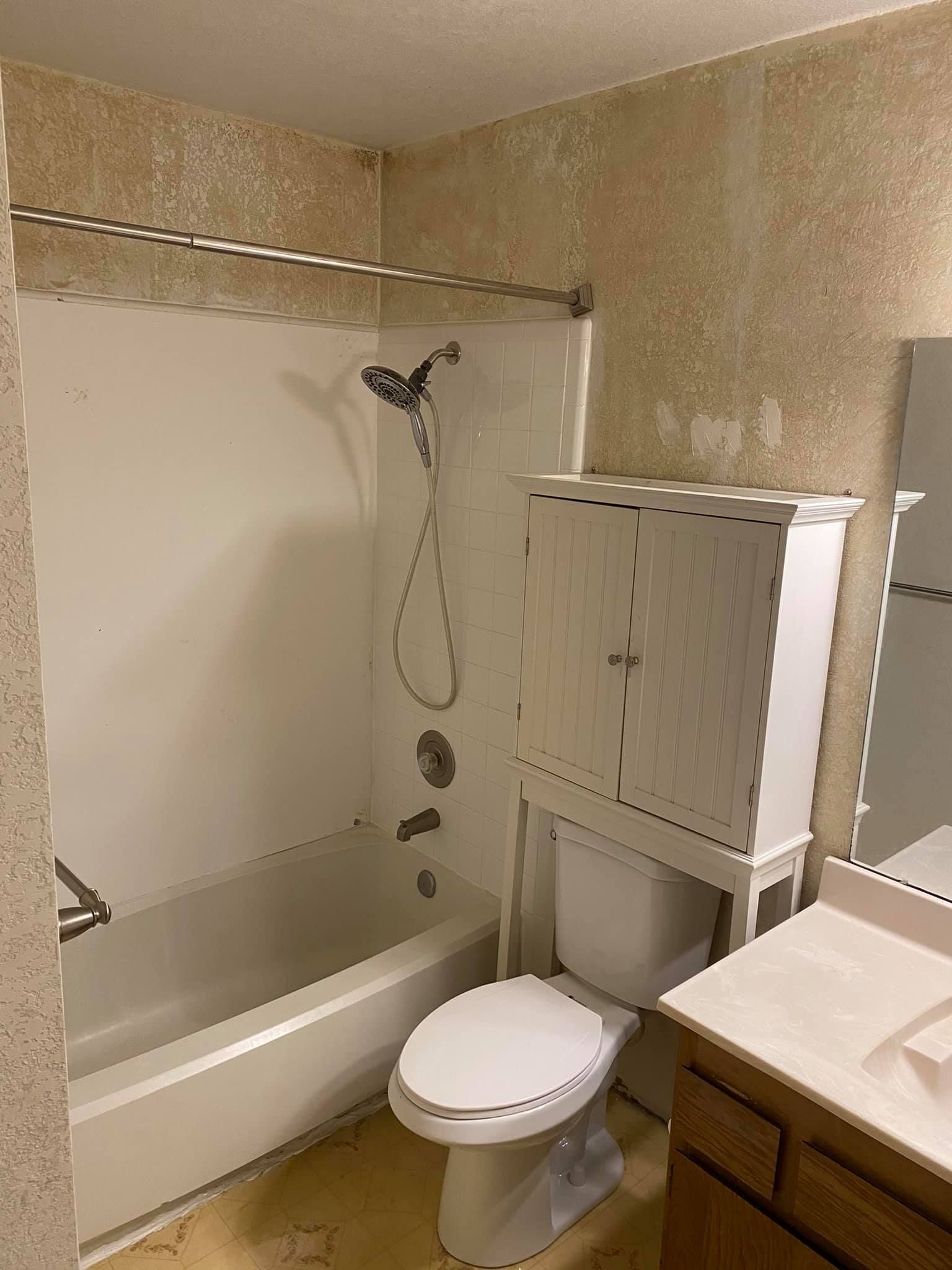 A bathroom with a toilet , sink , bathtub and shower.