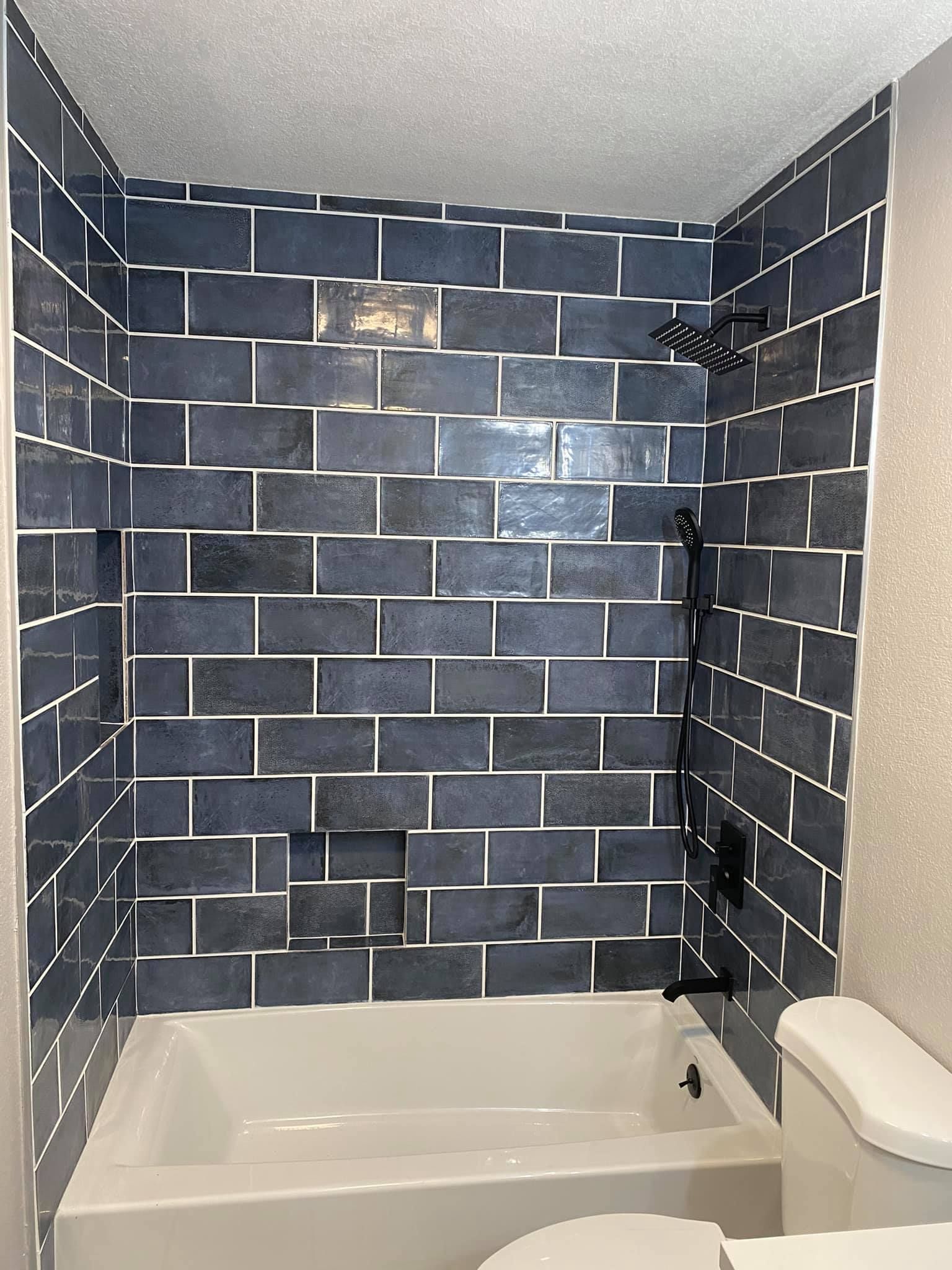 A bathroom with a bathtub , toilet and shower.