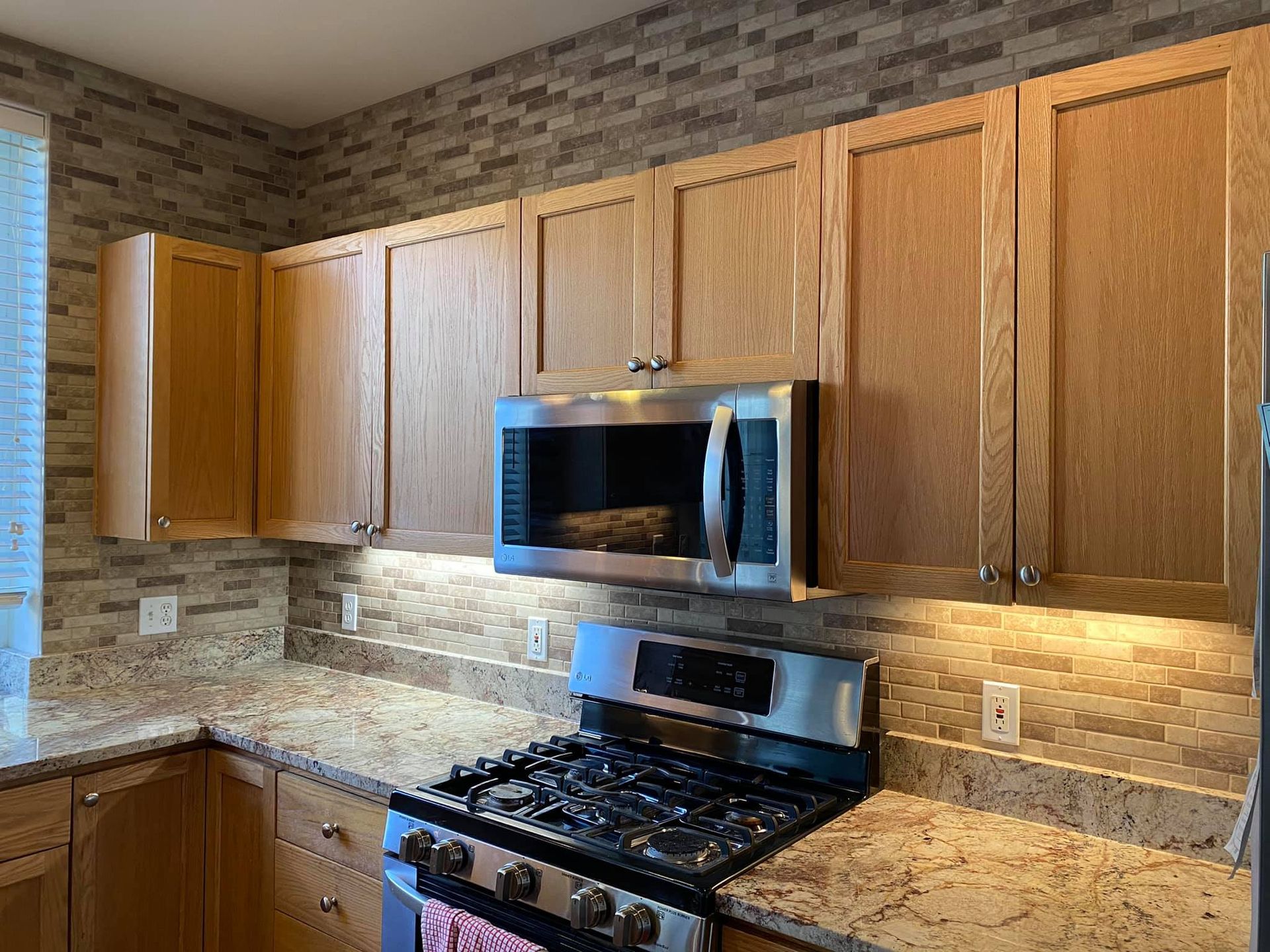 A kitchen with stainless steel appliances and wooden cabinets.