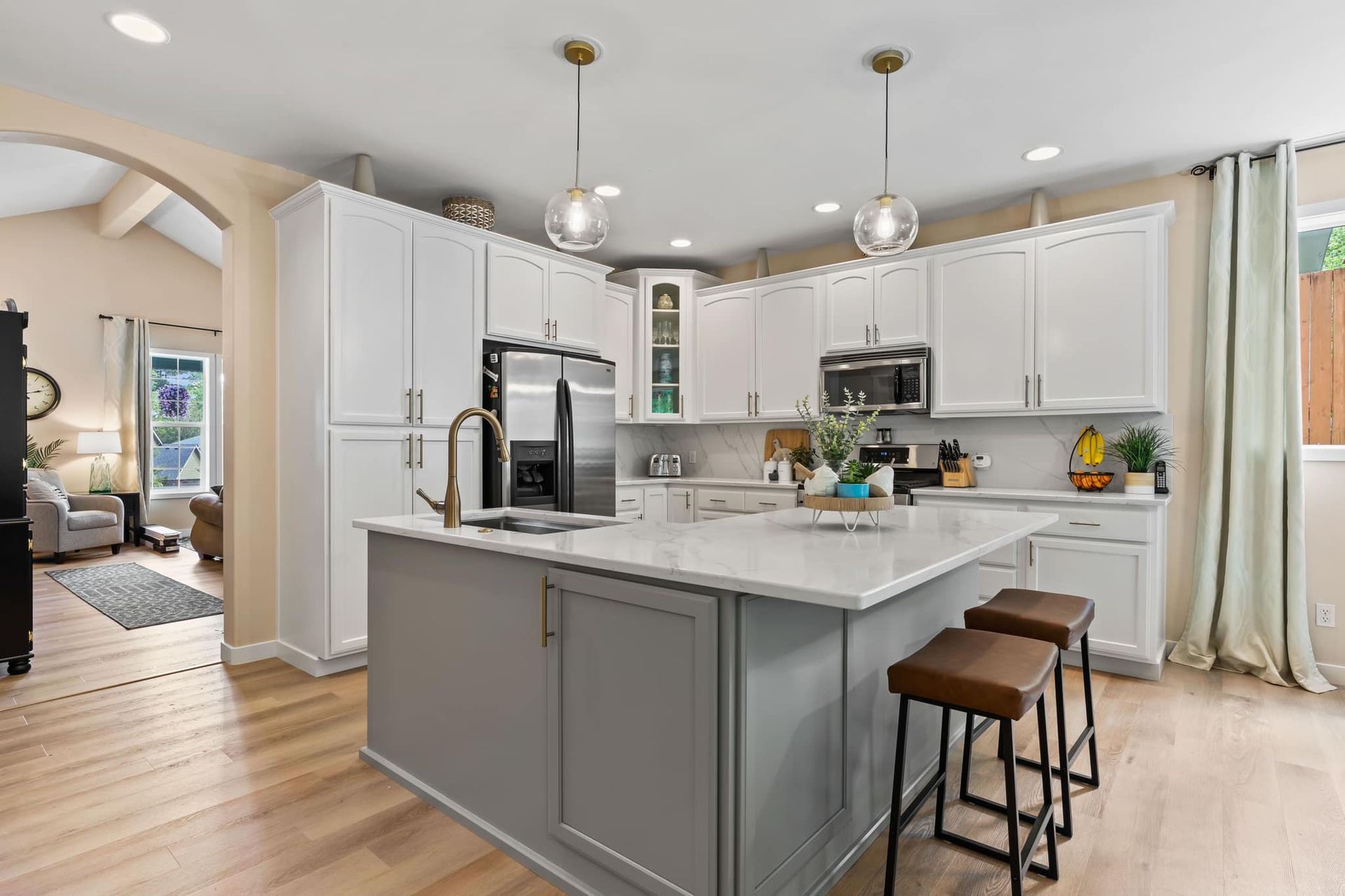 A kitchen with white cabinets and a large island in the middle.