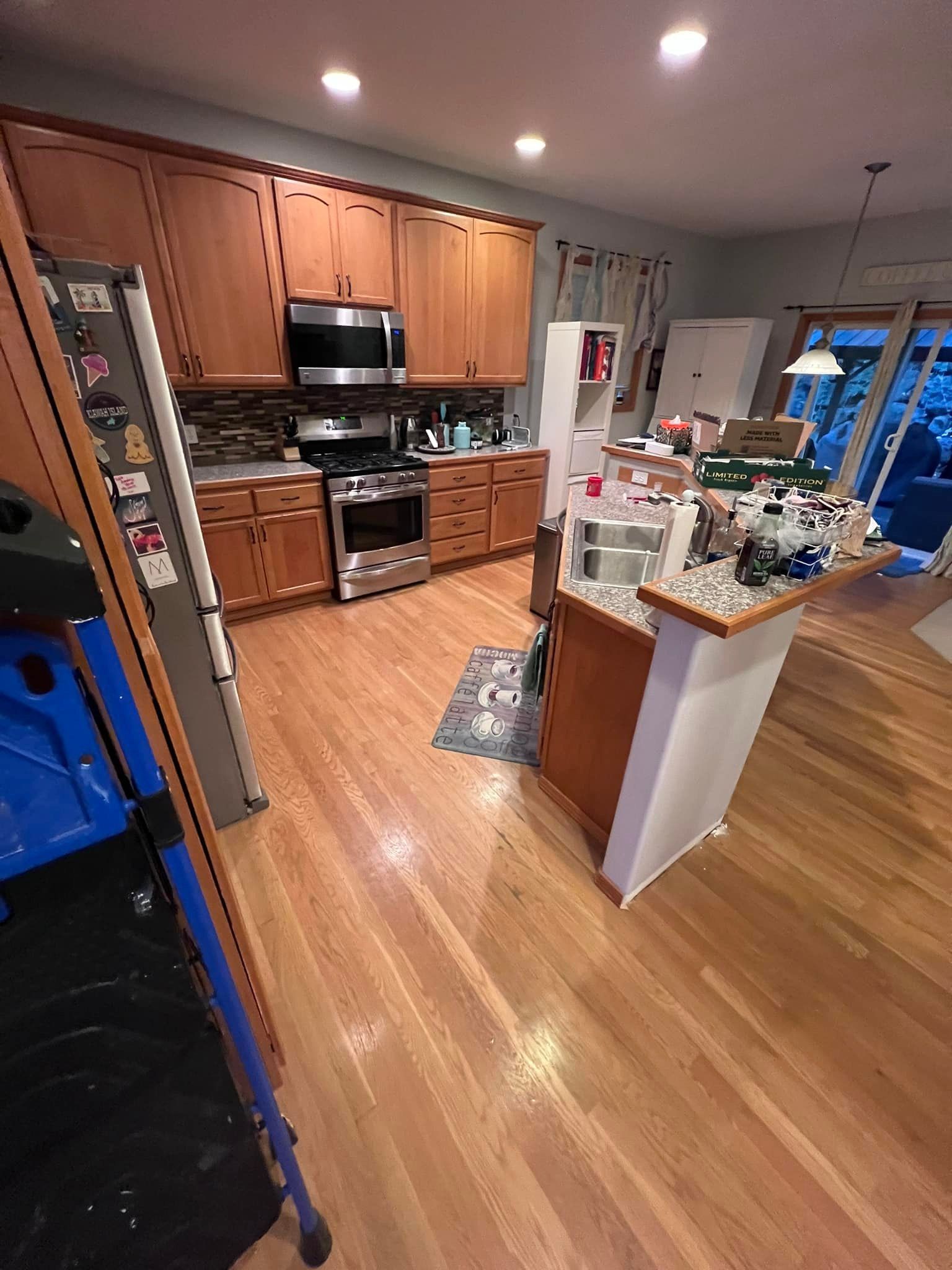A kitchen with hardwood floors and stainless steel appliances.
