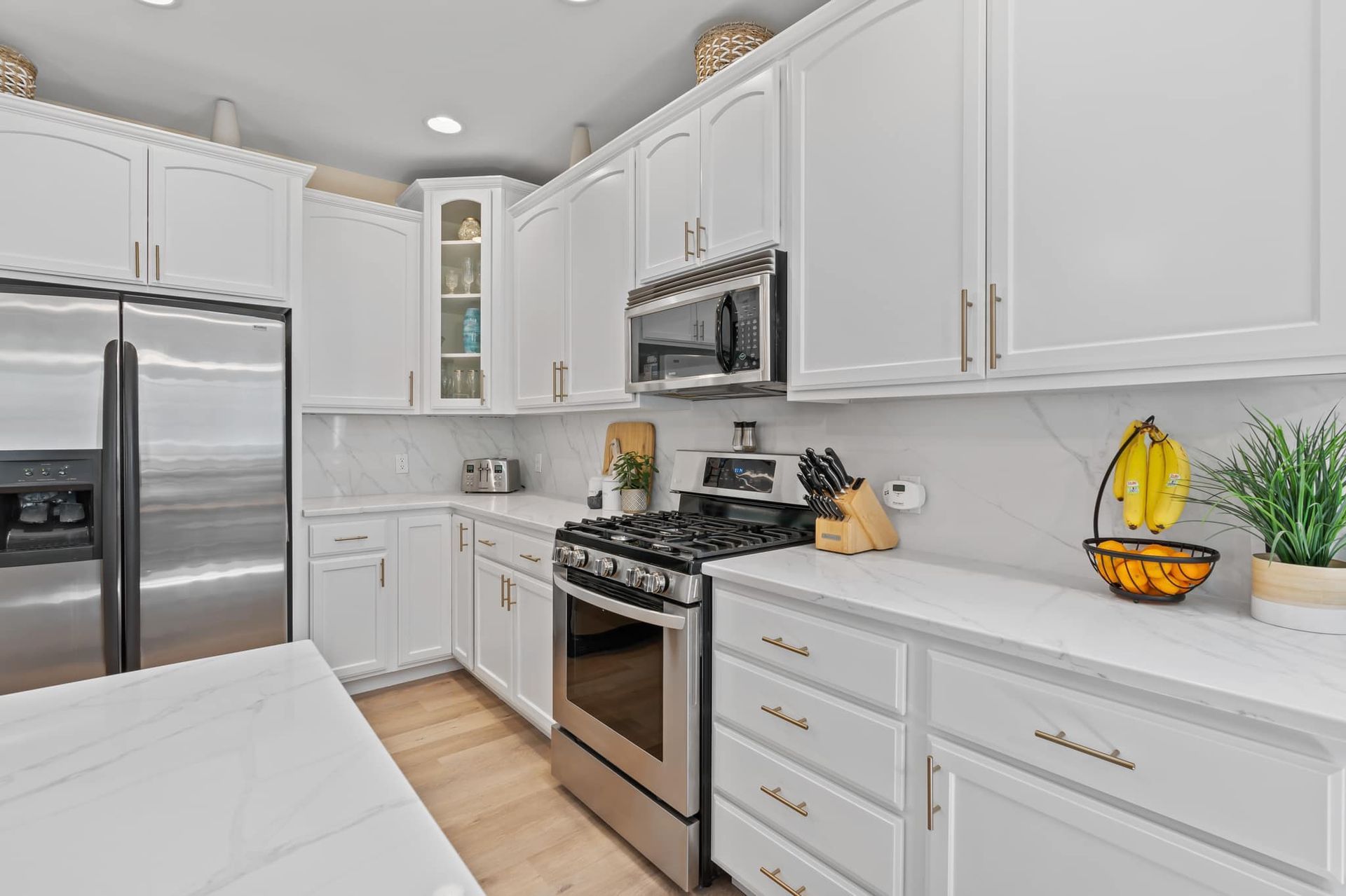A kitchen with white cabinets and stainless steel appliances.