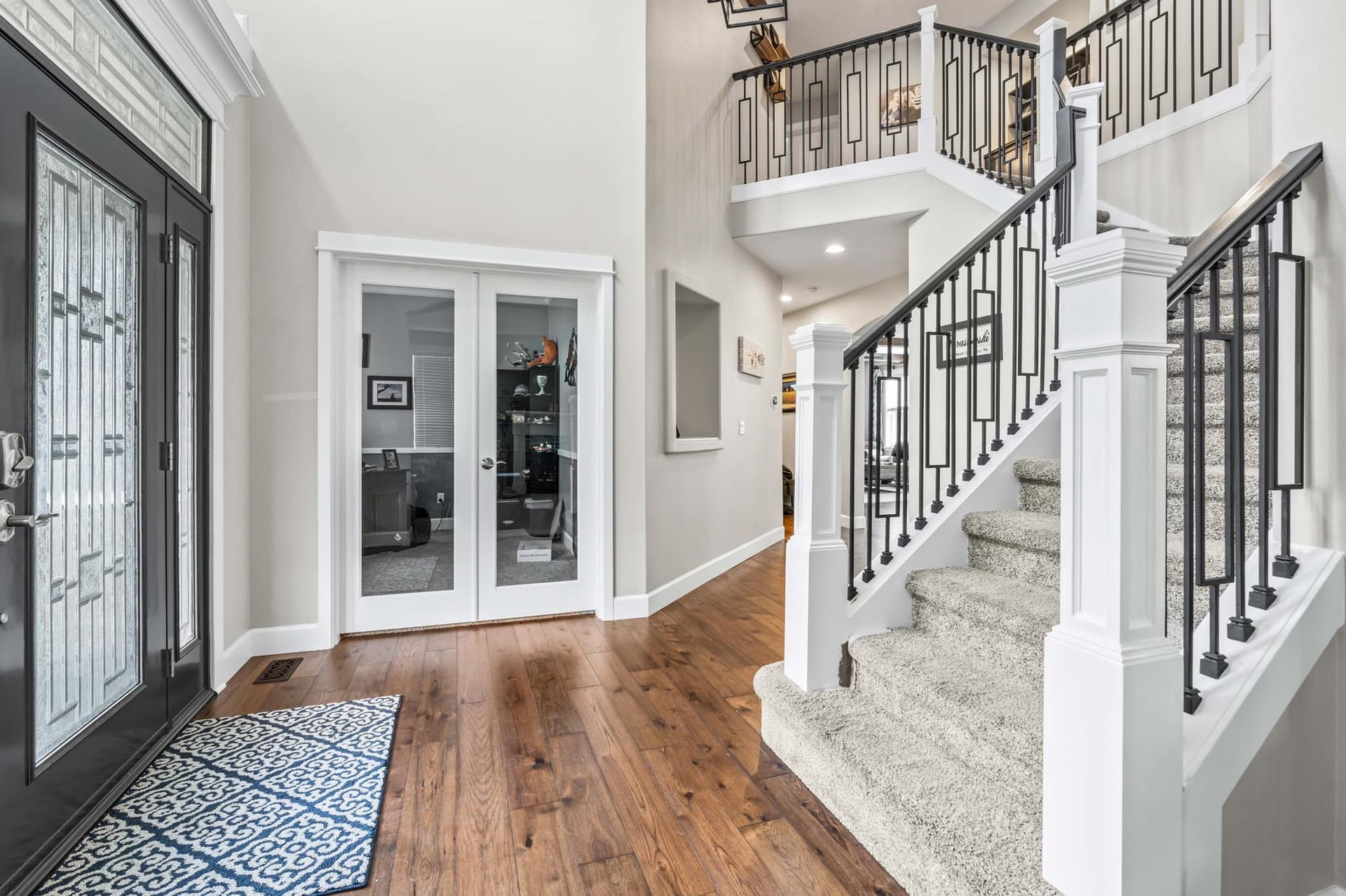A hallway with hardwood floors and stairs in a house.