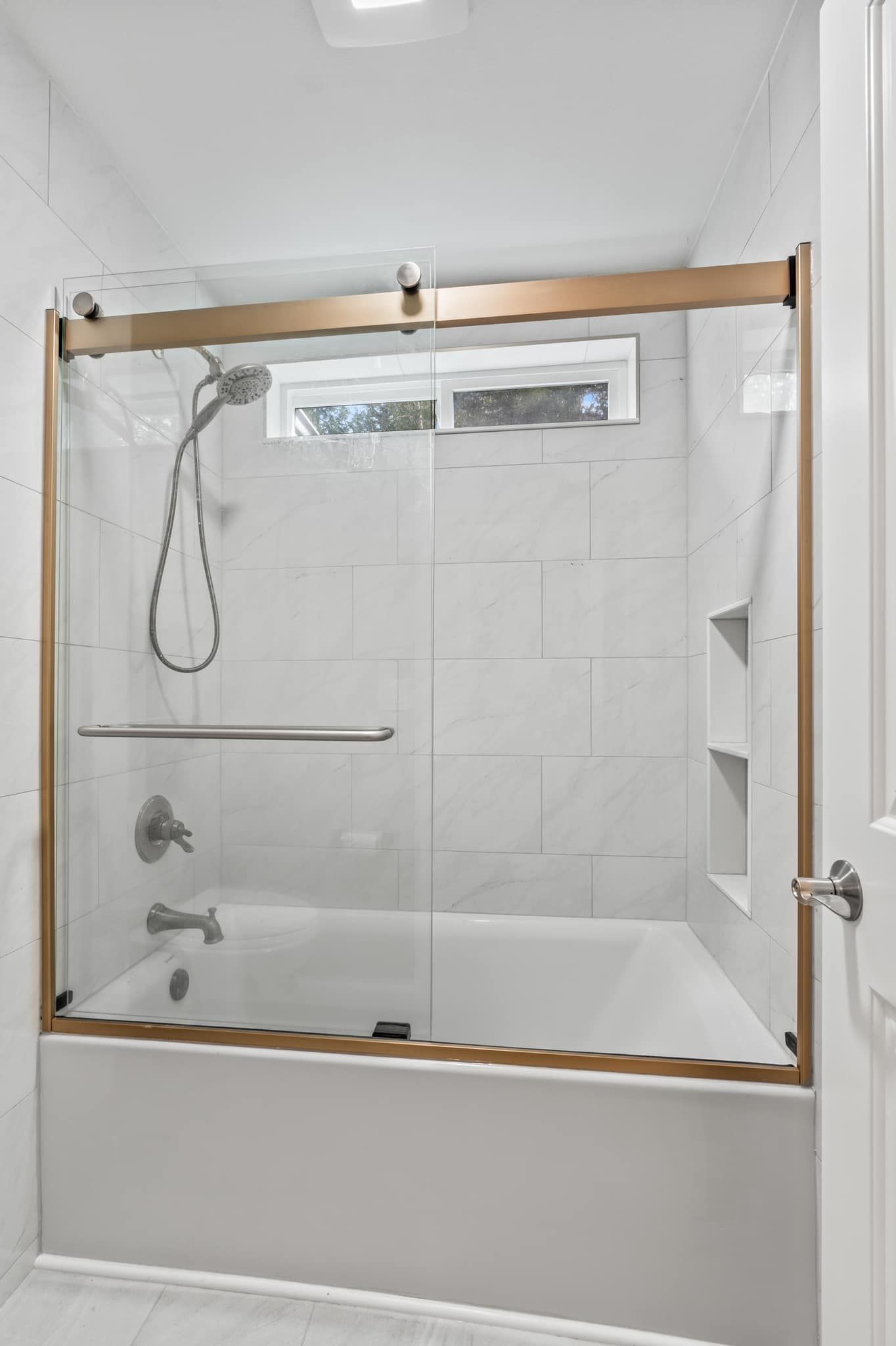 A bathroom with a bathtub and a shower with a sliding glass door.