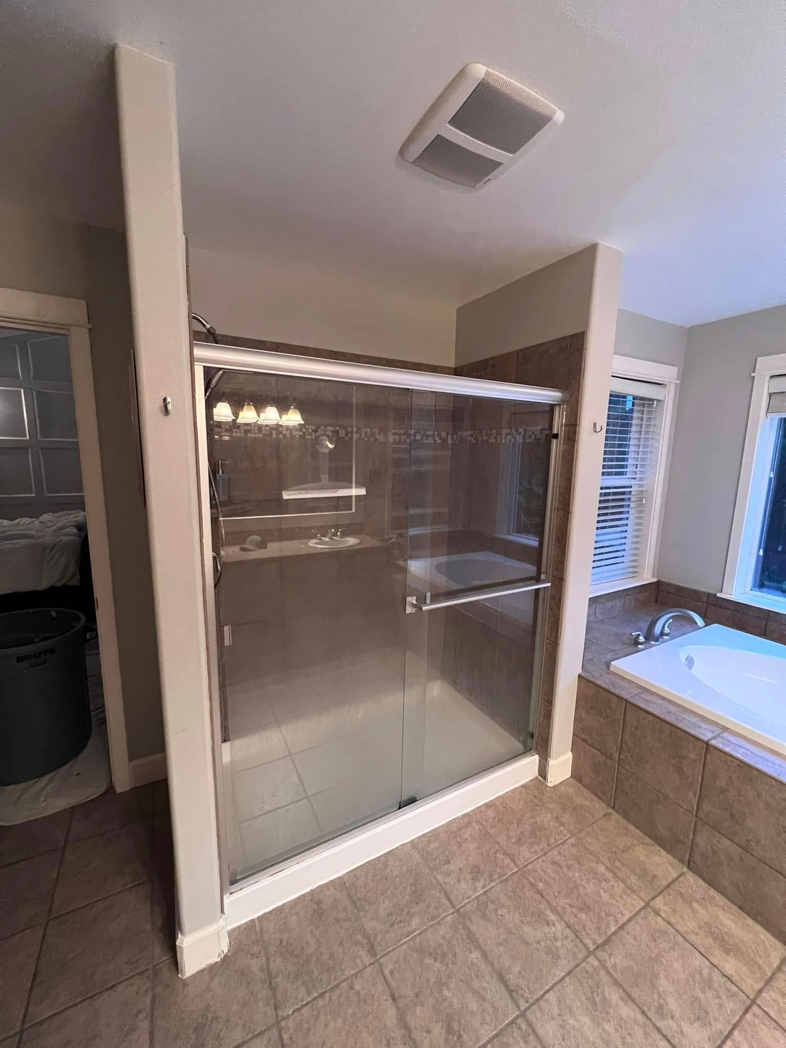 A bathroom with a walk in shower and a bathtub.
