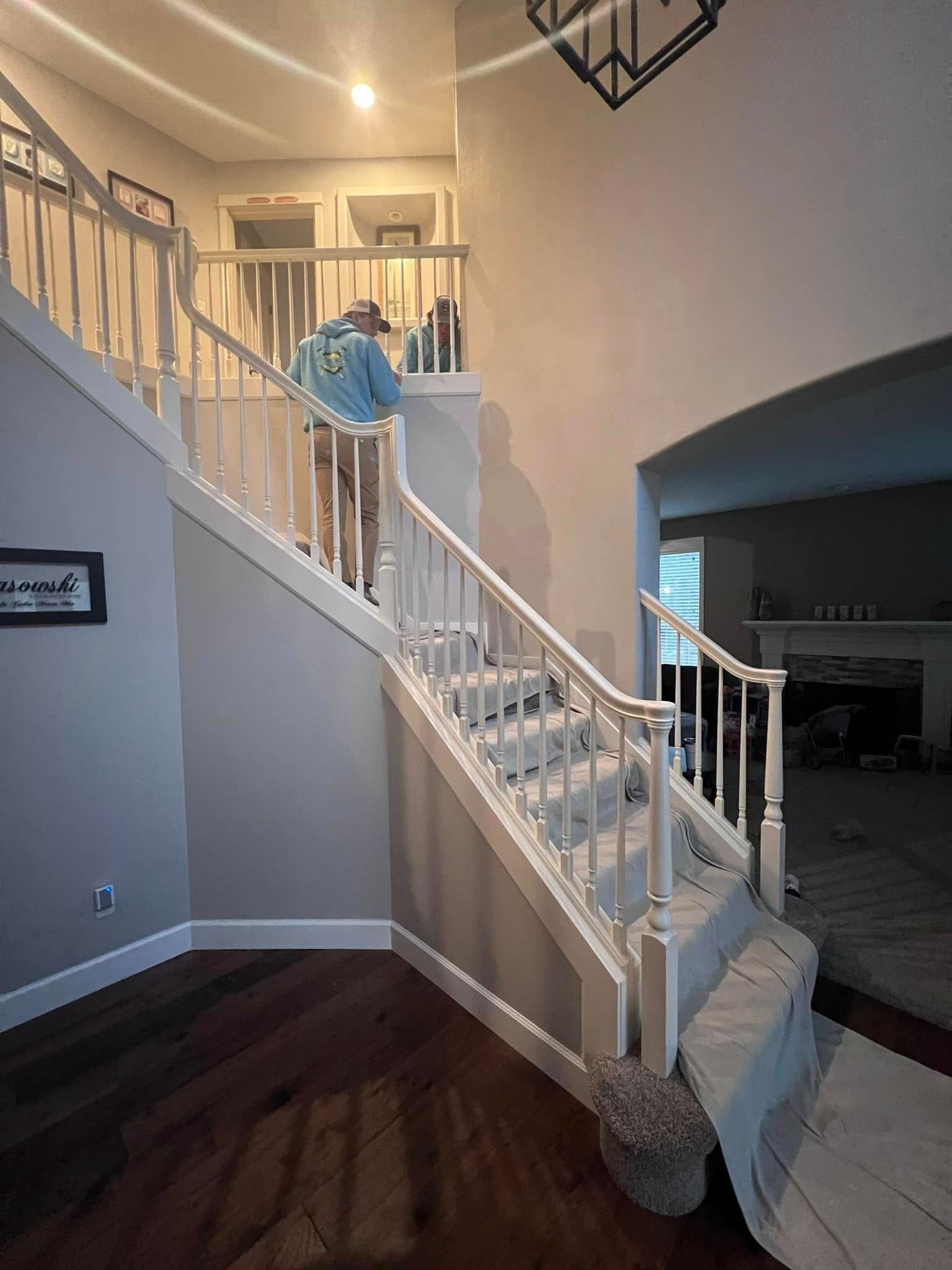 A man is standing on top of a set of stairs in a living room.