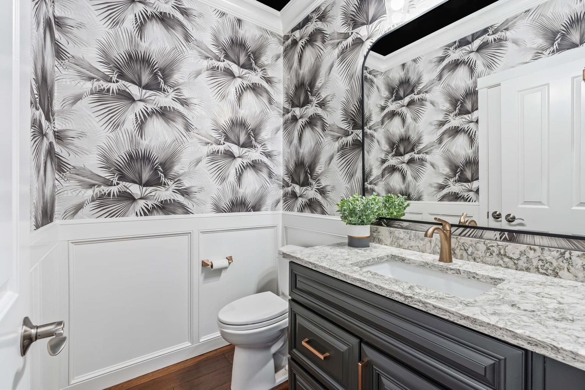 A bathroom with a toilet , sink and mirror.