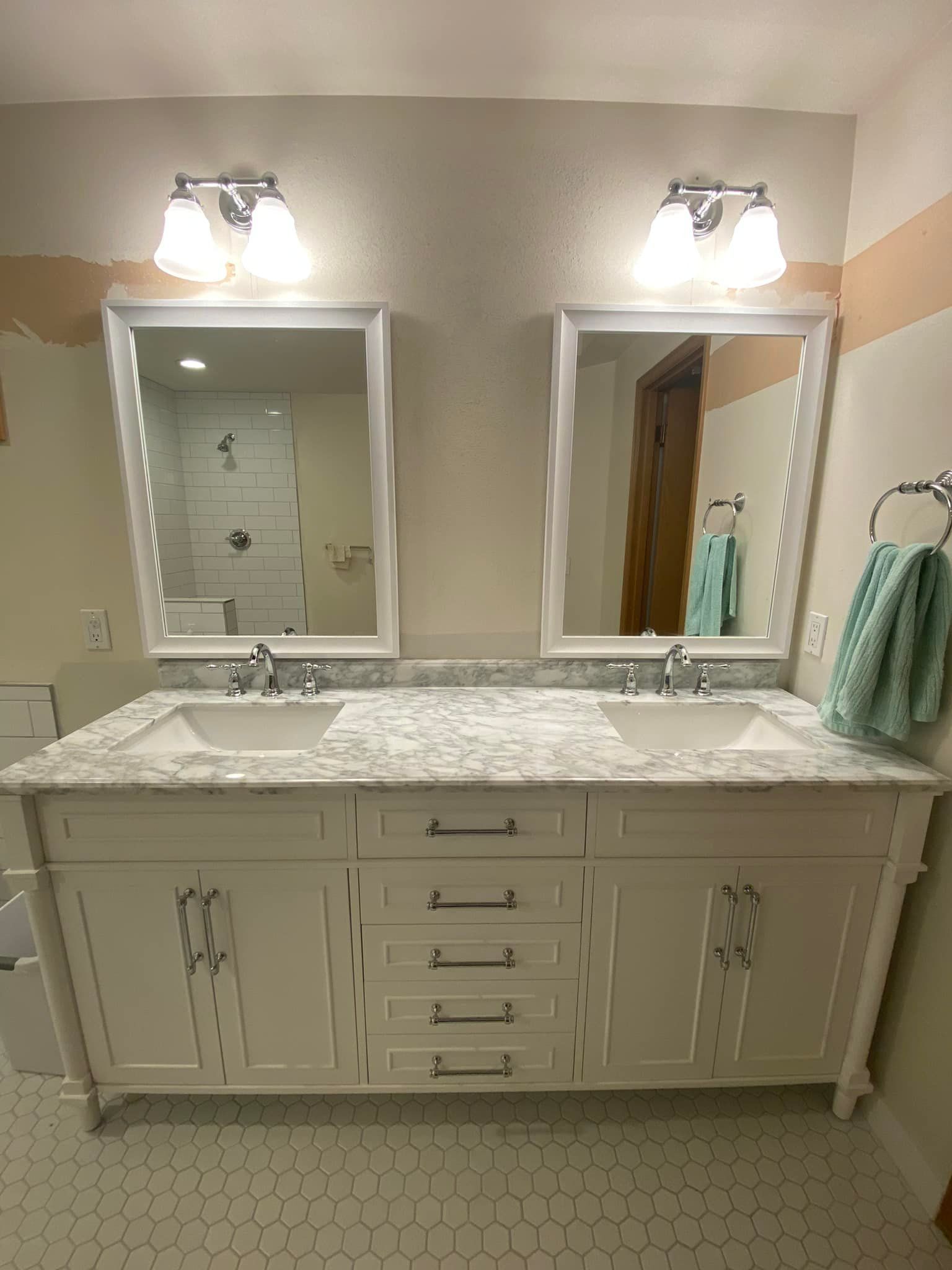 A bathroom with two sinks and two mirrors.
