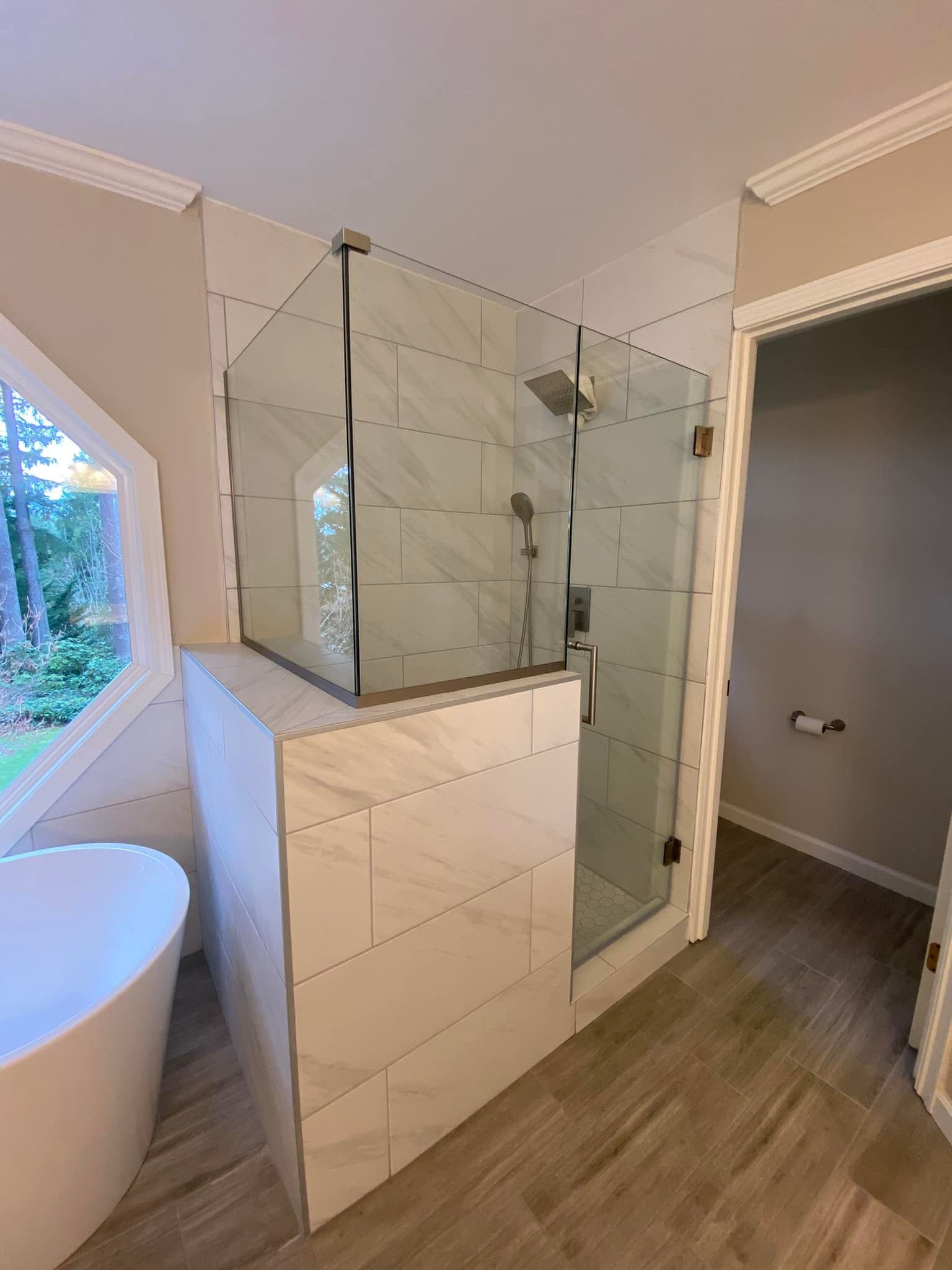 A bathroom with a walk in shower and a bathtub.