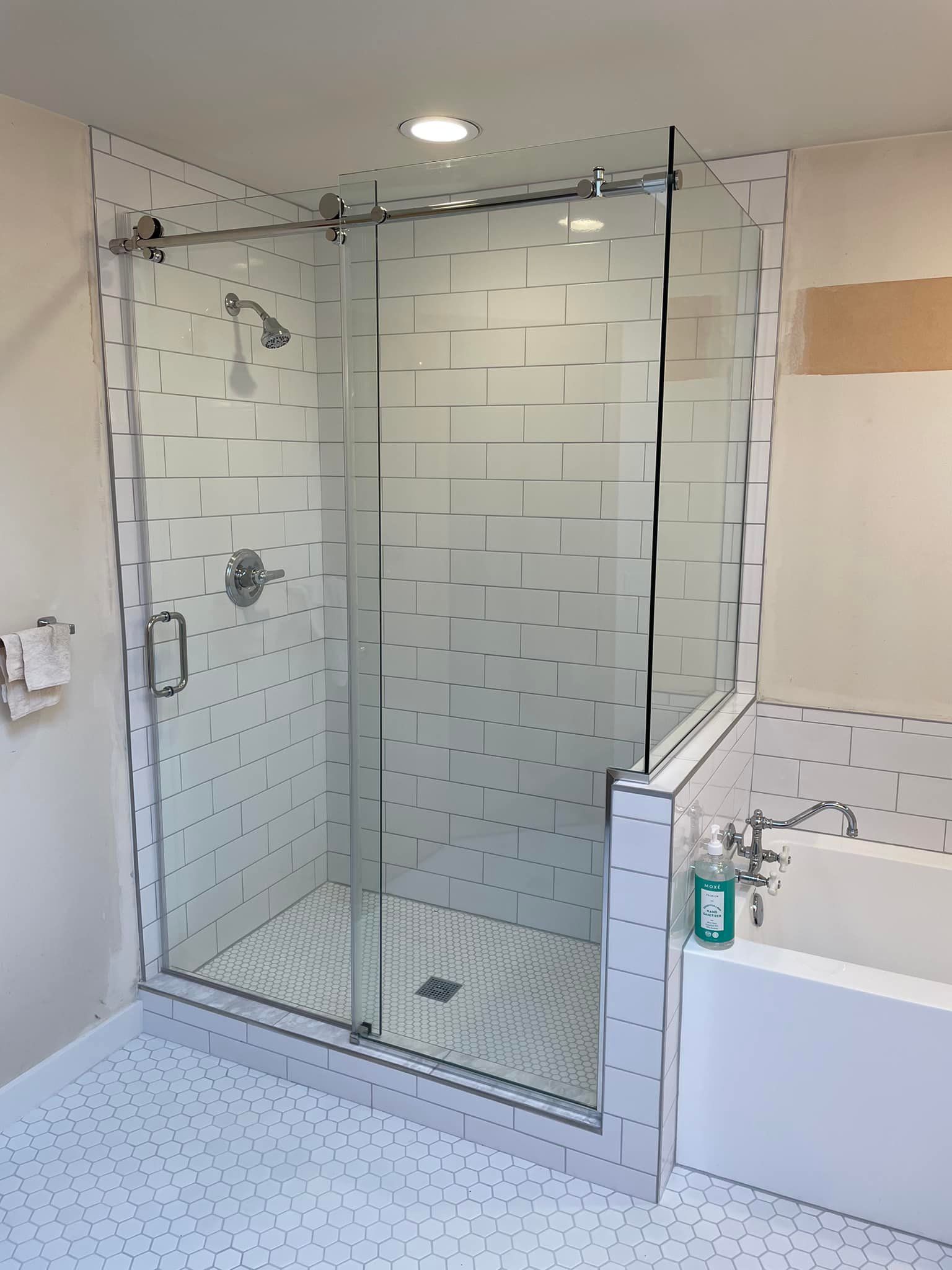 A bathroom with a walk in shower and a bathtub.