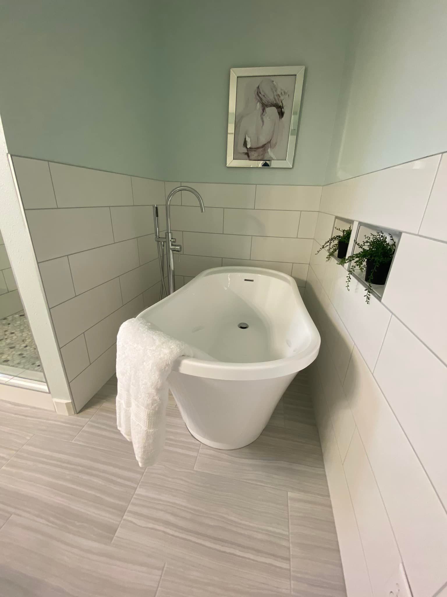 A bathroom with a bathtub and a picture on the wall.