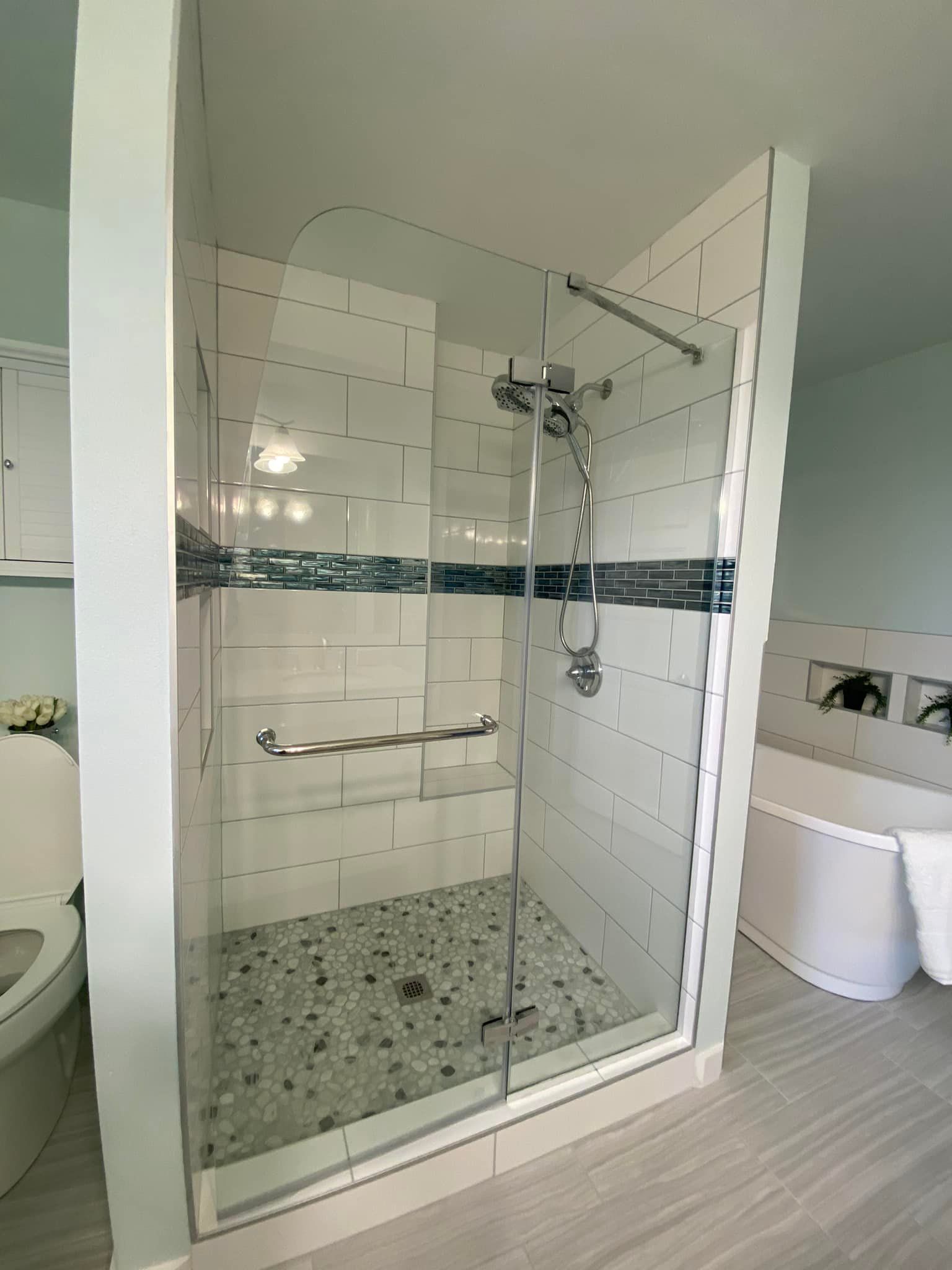 A bathroom with a walk in shower and a bathtub.