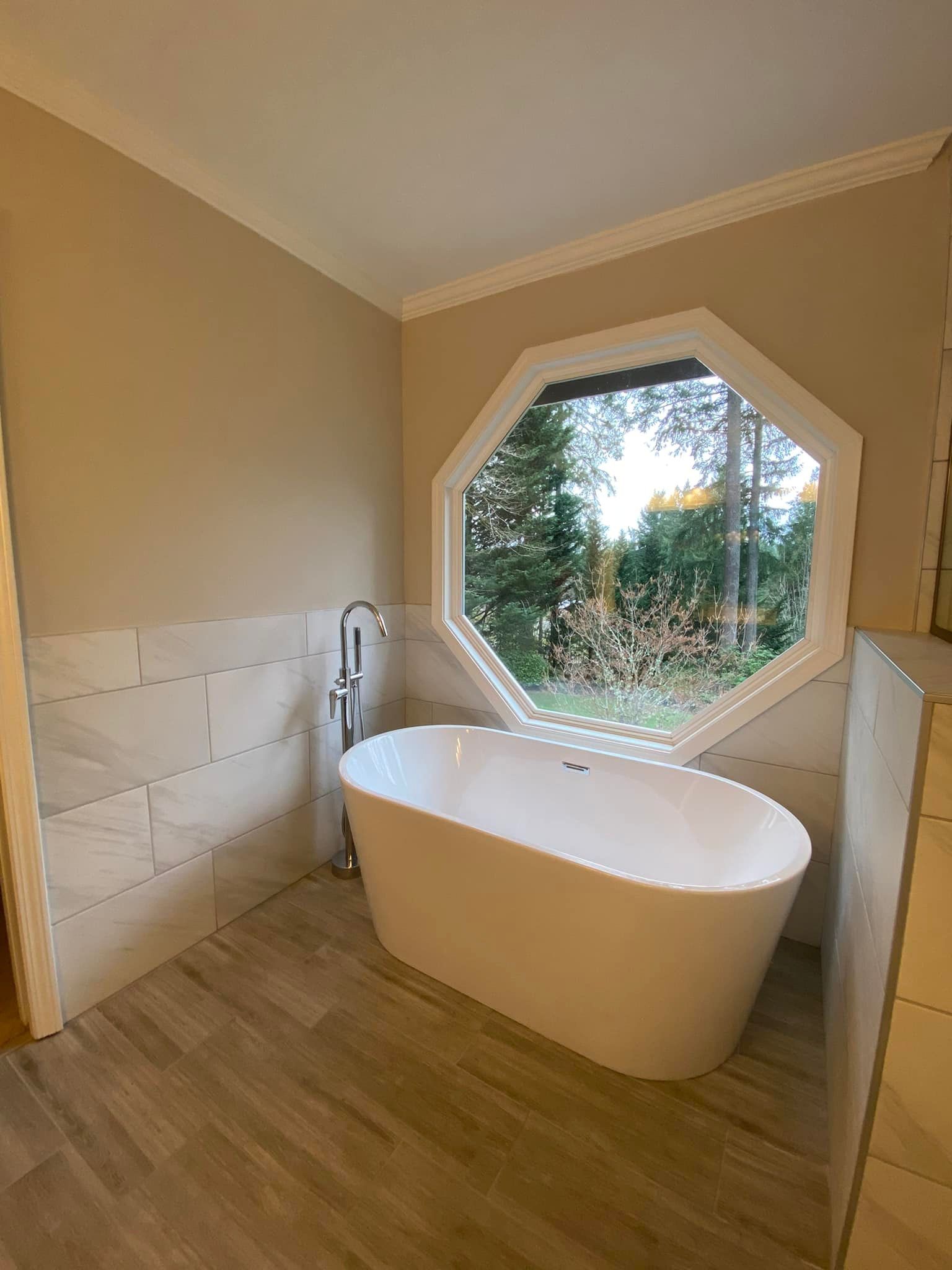 A bathroom with a bathtub and a window.