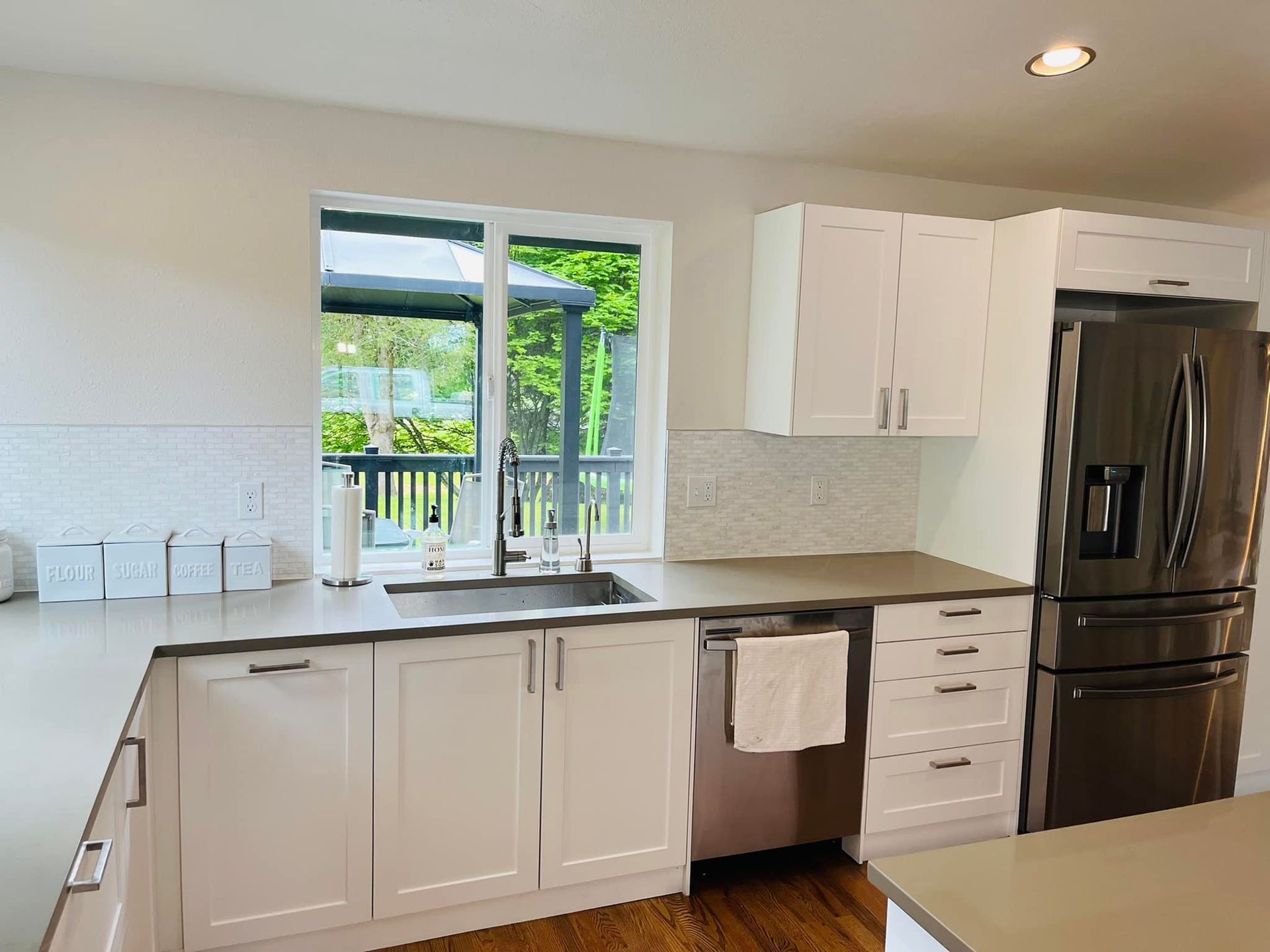 A kitchen with white cabinets and stainless steel appliances