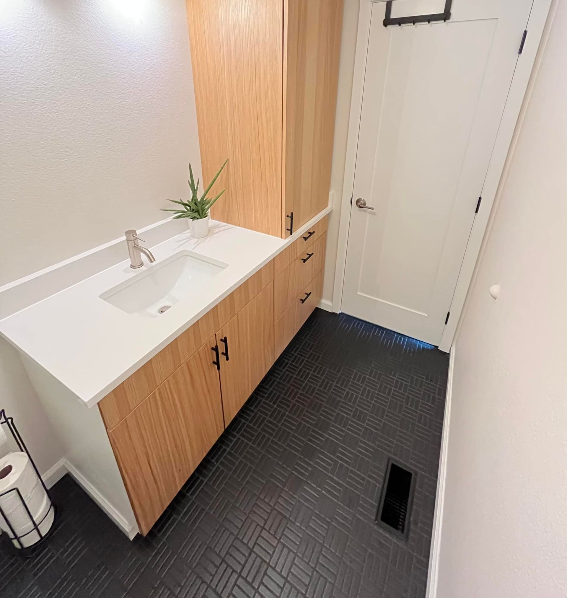 A bathroom with a sink and wooden cabinets