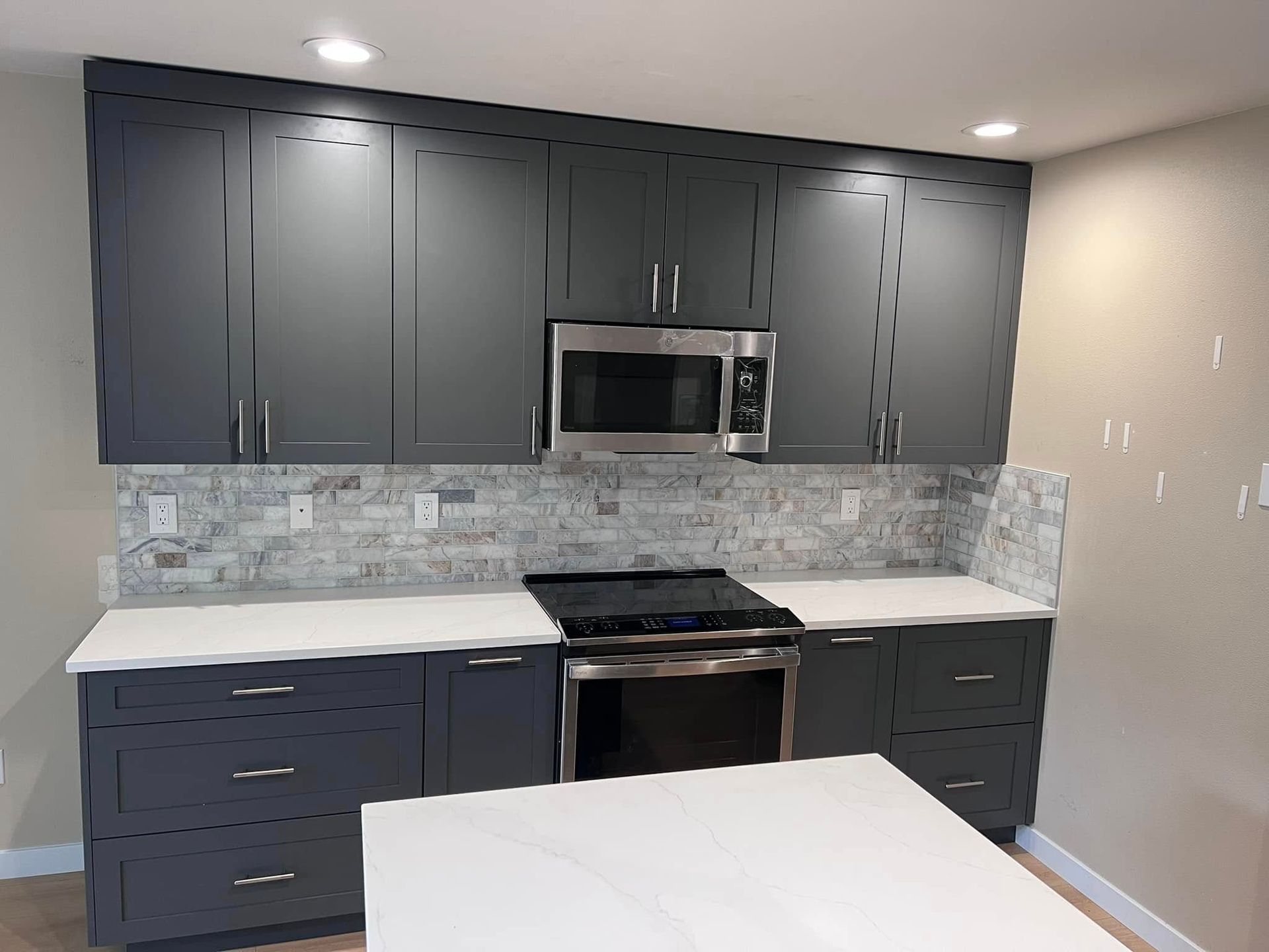 A kitchen with stainless steel appliances and gray cabinets