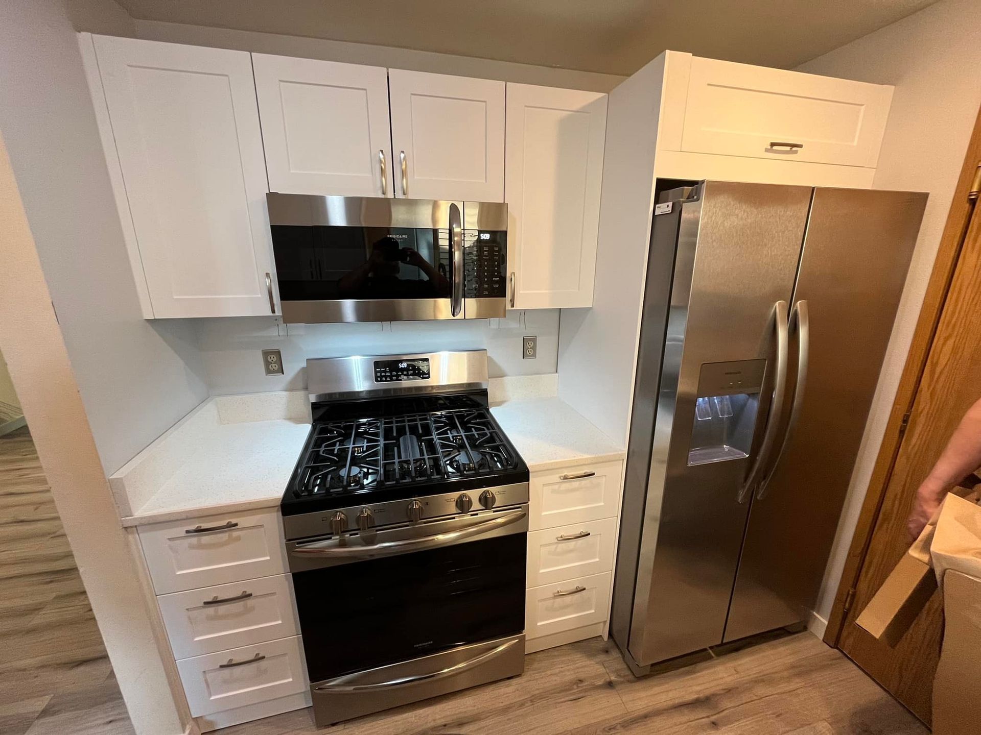 A kitchen with stainless steel appliances and white cabinets.