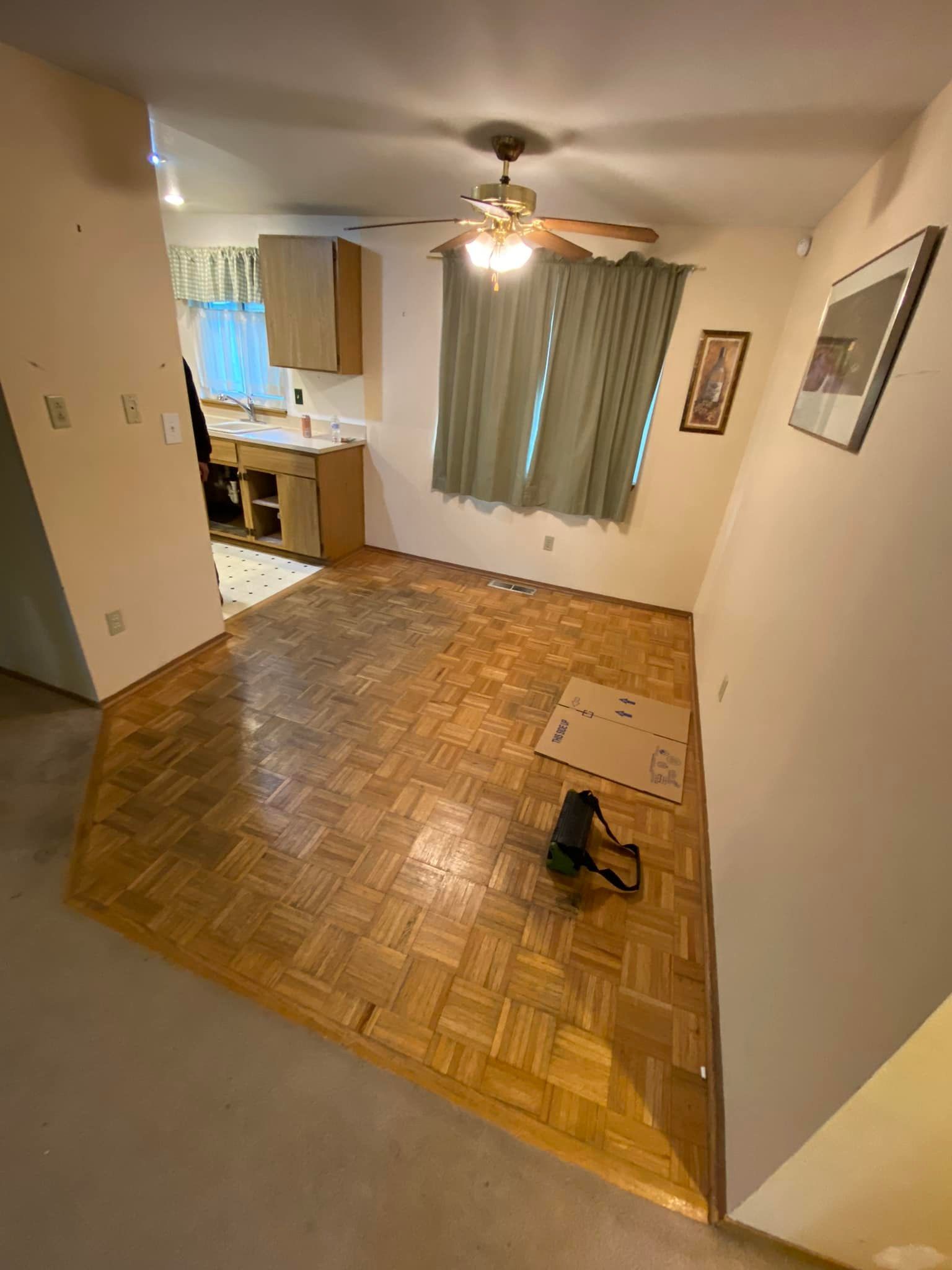 A living room with a wooden floor and a ceiling fan.