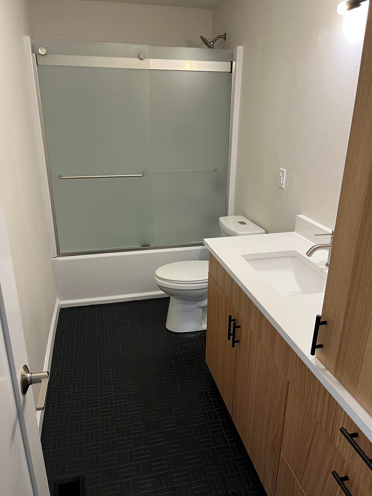 A bathroom with a toilet , sink , and shower.