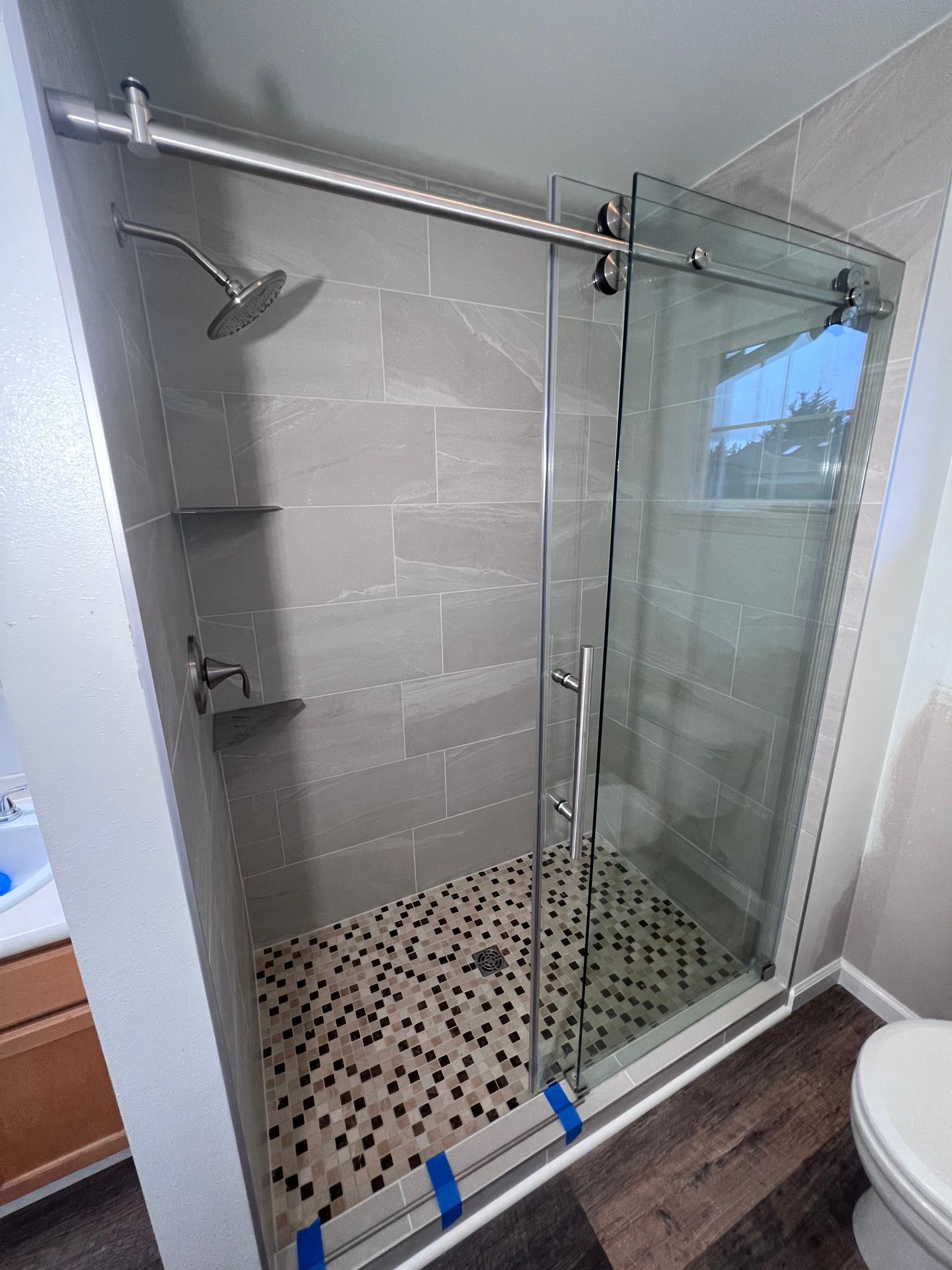 A bathroom with a sliding glass shower door and a toilet.