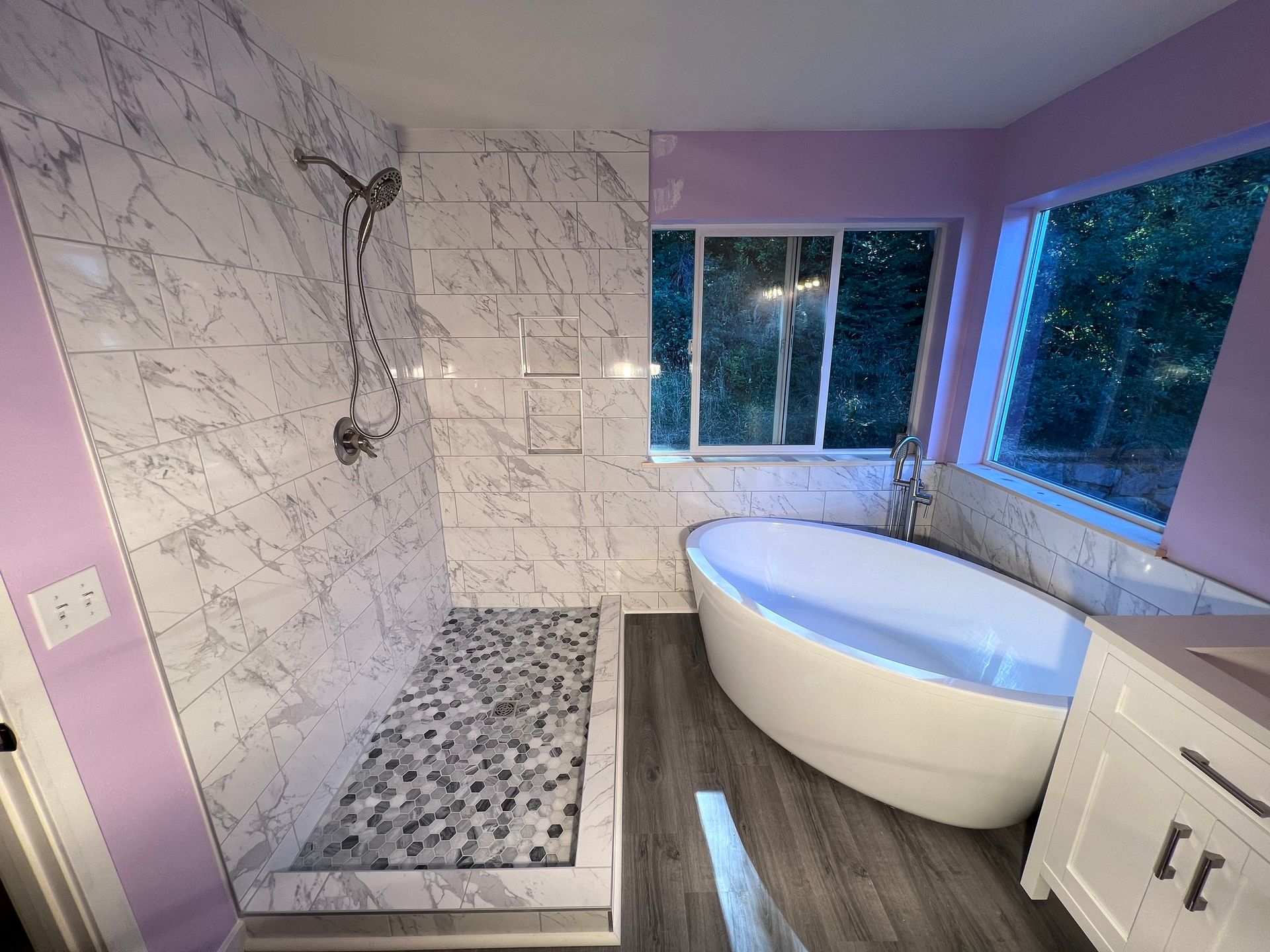 A bathroom with a tub , shower and window.