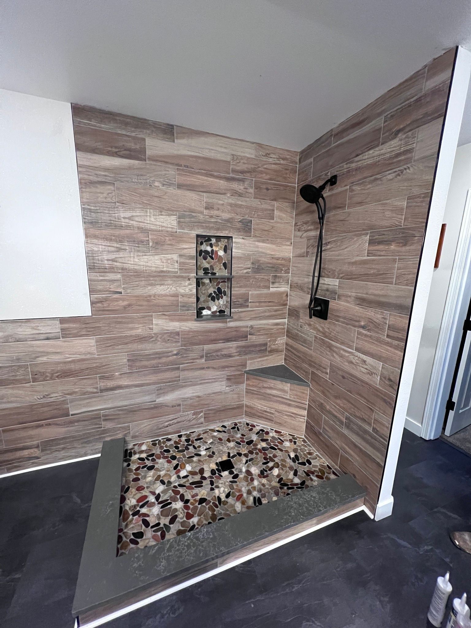 A bathroom with a walk in shower and wooden walls.