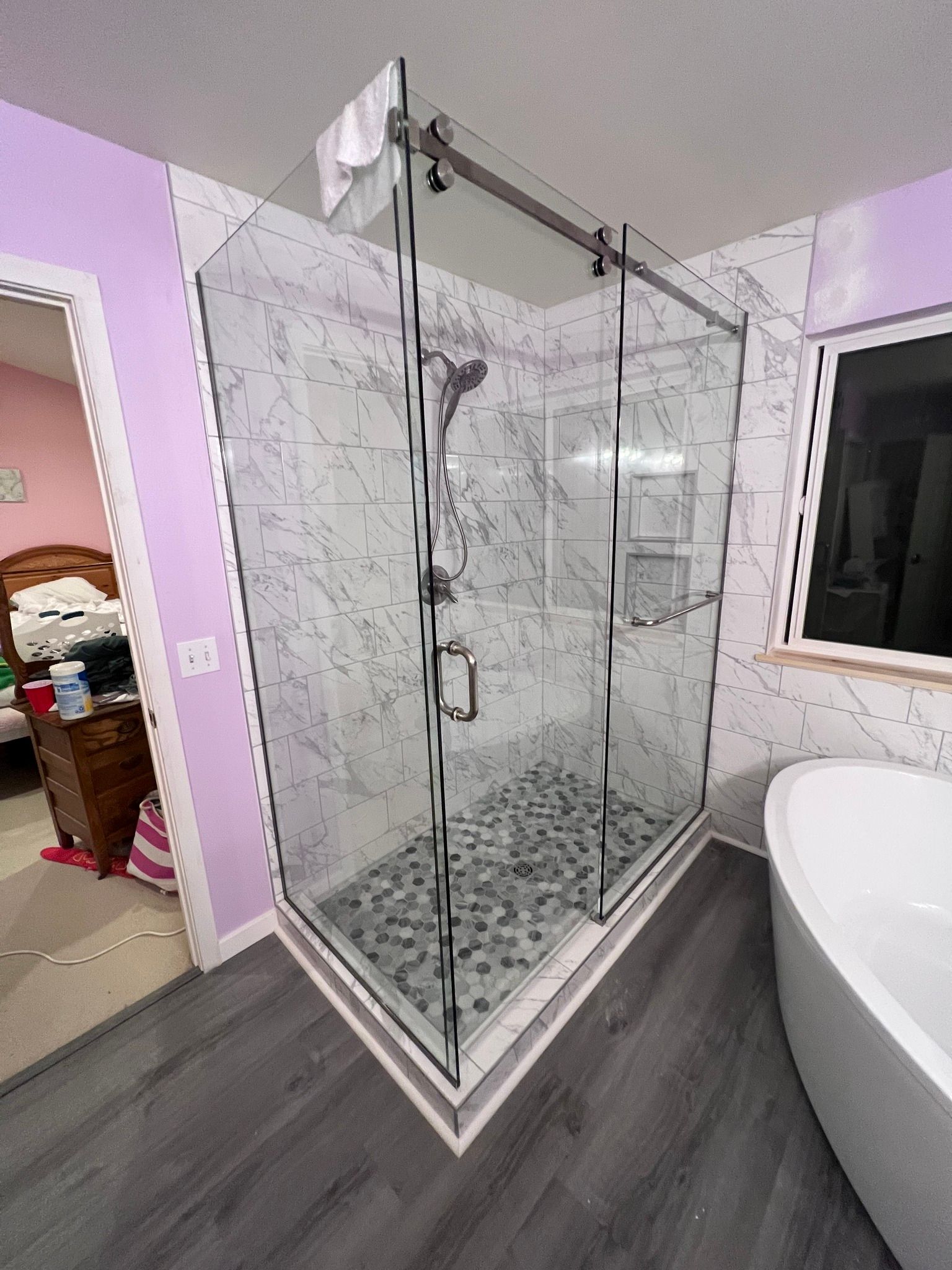 A bathroom with a walk in shower and a bathtub.